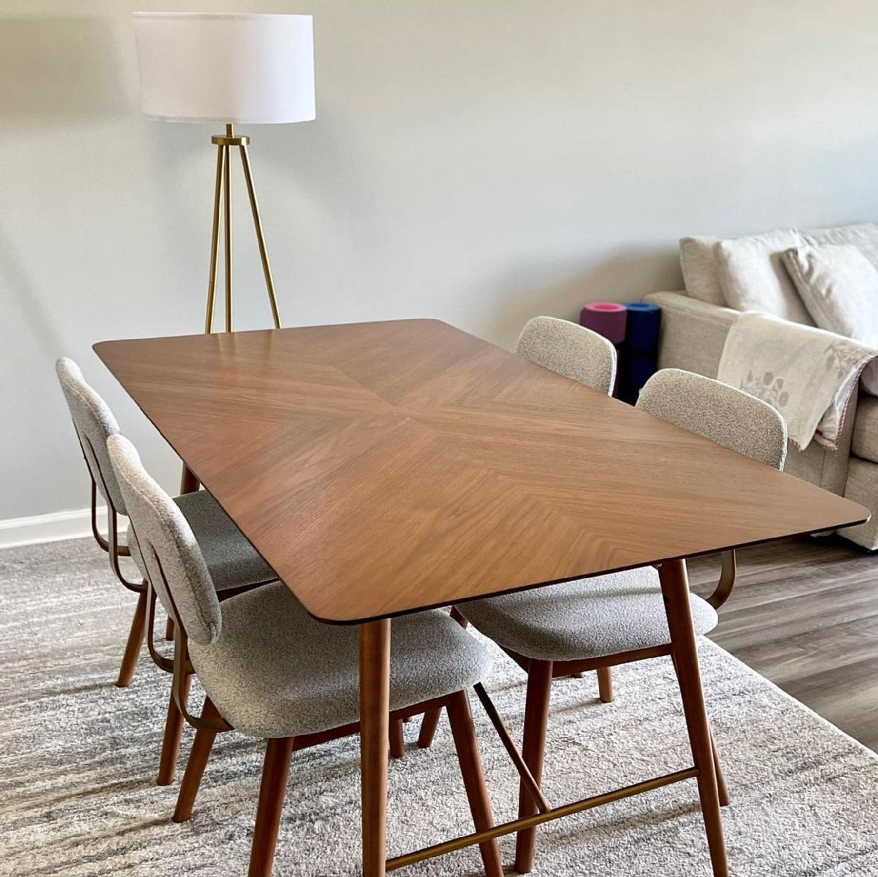 A wooden dining table with striking chevron patterns and matching dining chairs.