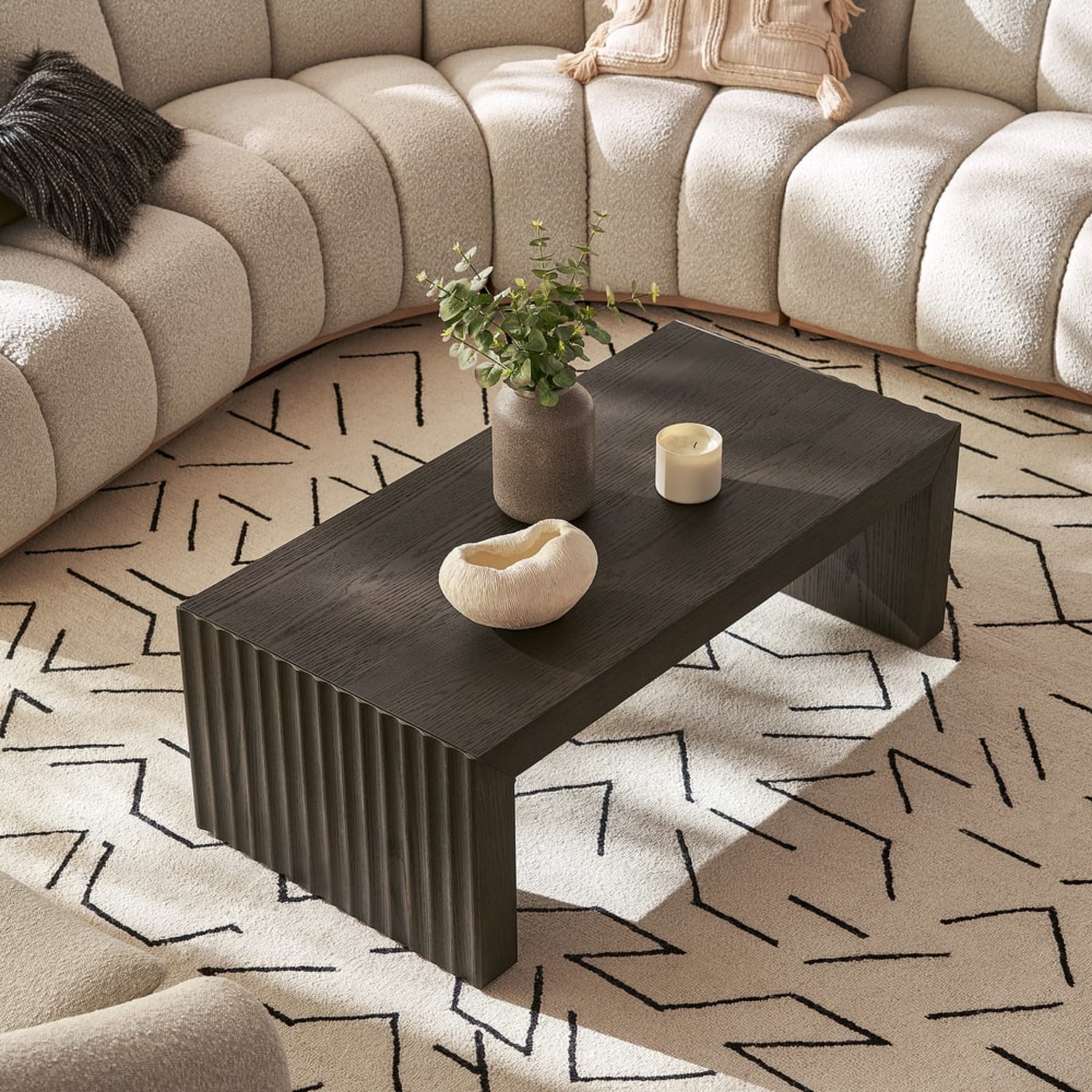 A black rectangular coffee table with fluted panels.