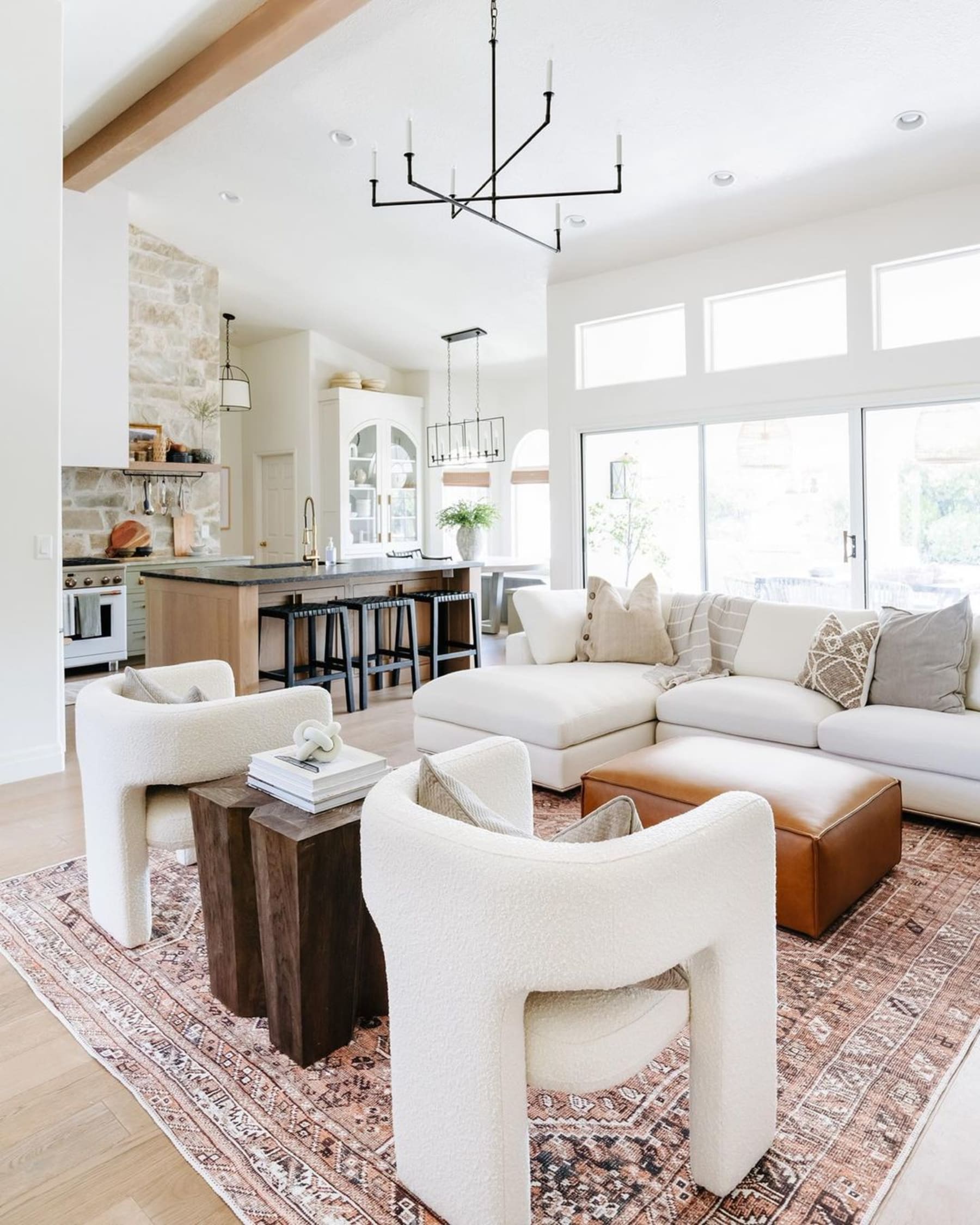 A sectional sofa, 2 matching armchairs, and a leather ottoman used as a coffee table.