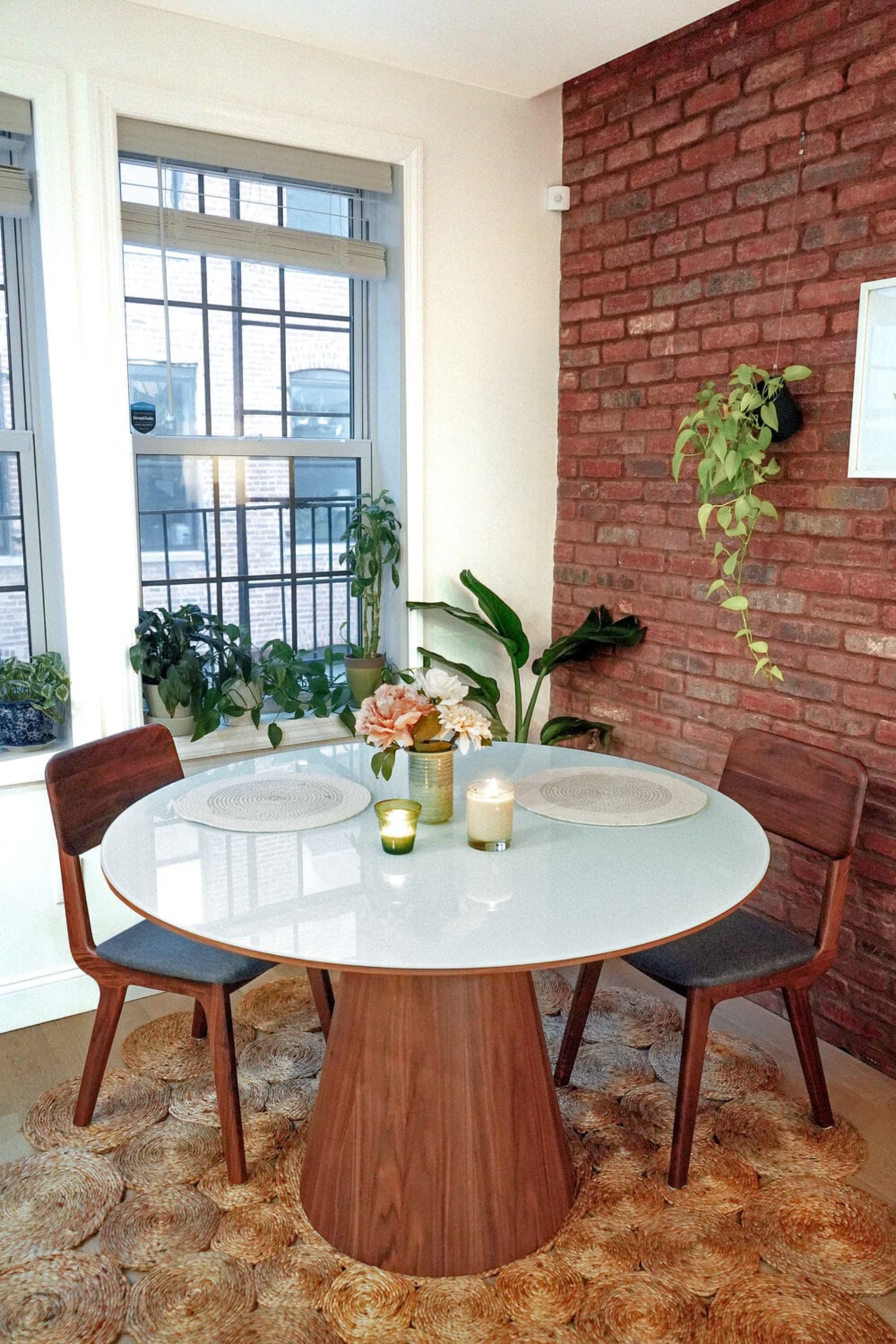 A round dining table with a glass tabletop and 2 chairs.