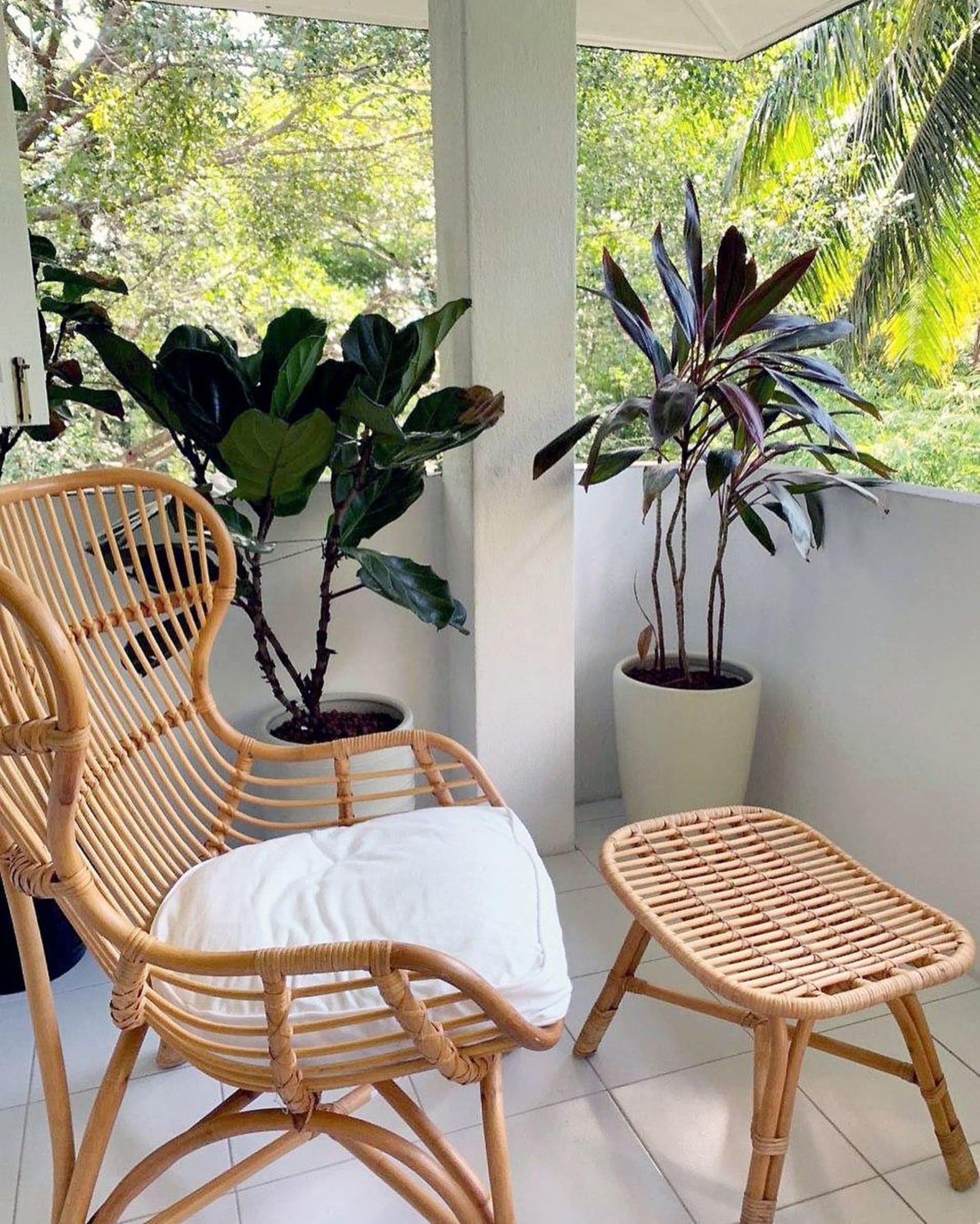 A rattan armchair with a white seat cushion and matching stool.  Caption: The Mico Rattan Armchair and Stool that gives off a tropical vibe.