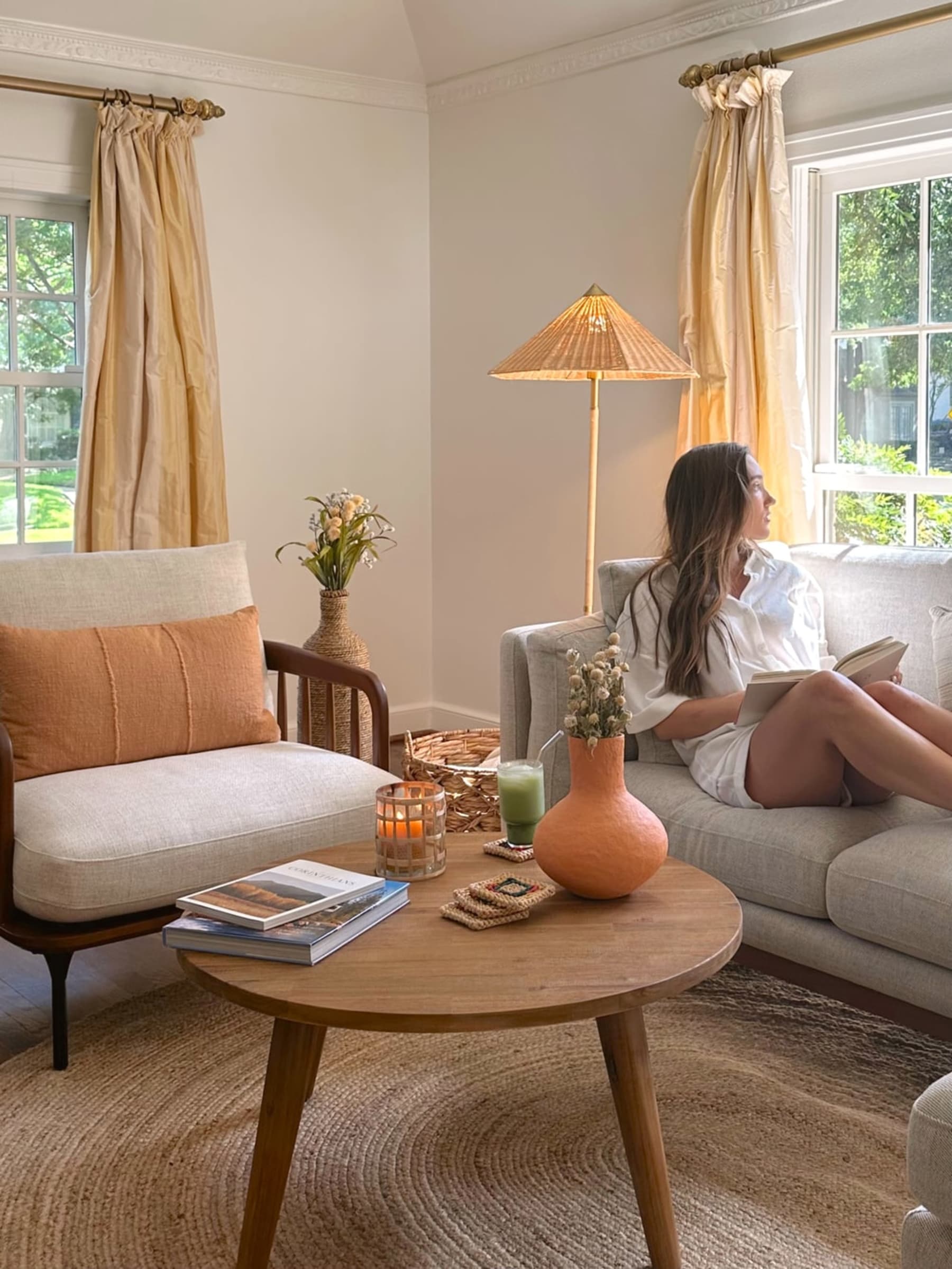 A person is sitting on a fabric sofa holding a book.