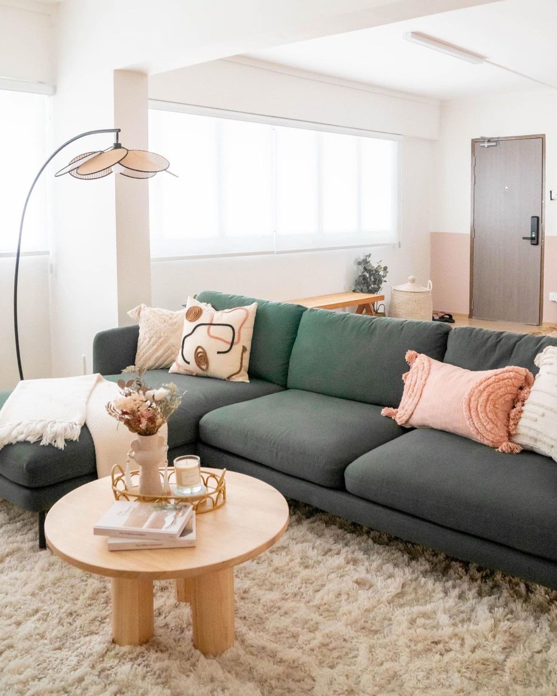 A green chaise sectional sofa and a round wooden coffee table.