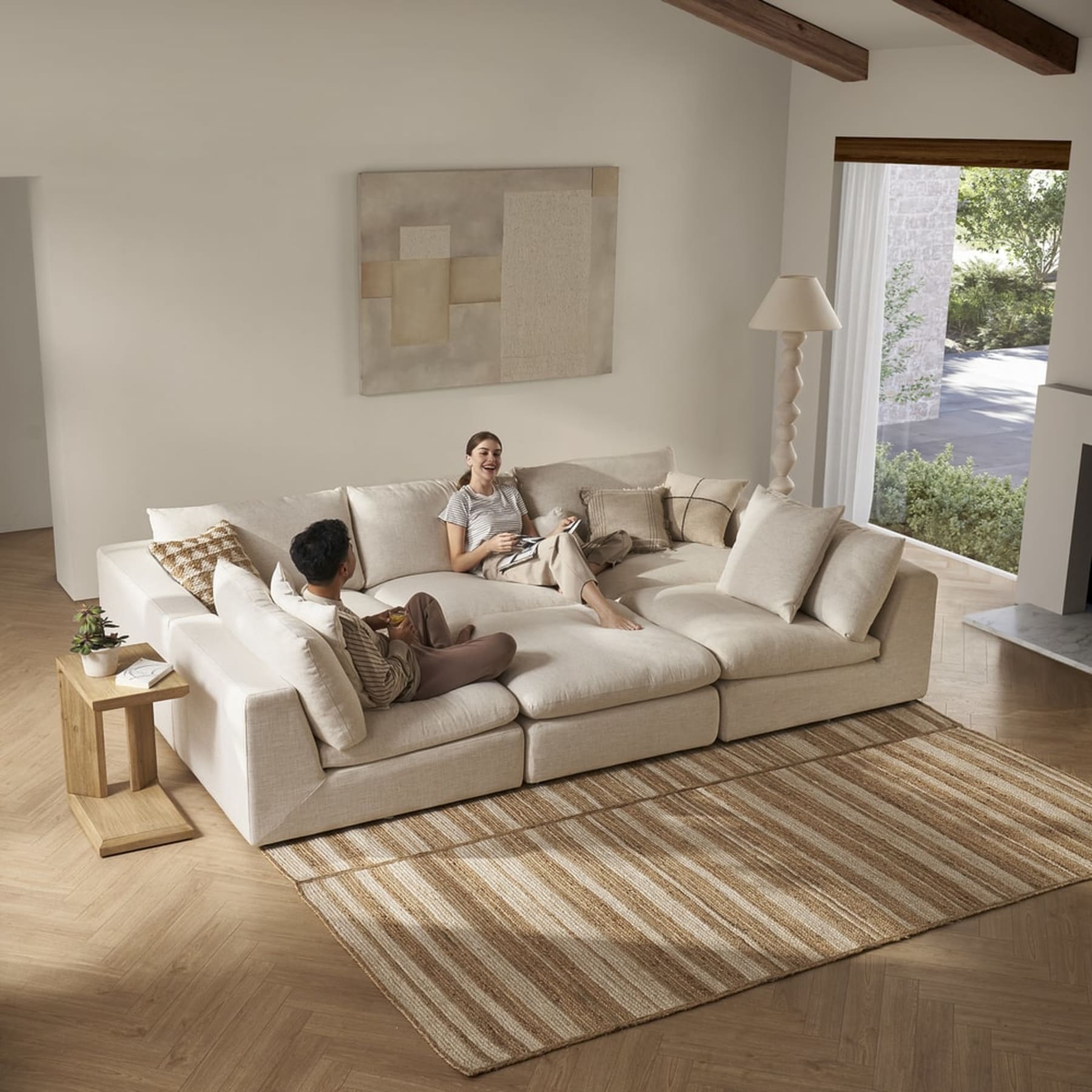 A sectional sofa, leather ottoman, and 2 matching armchairs in a living room.