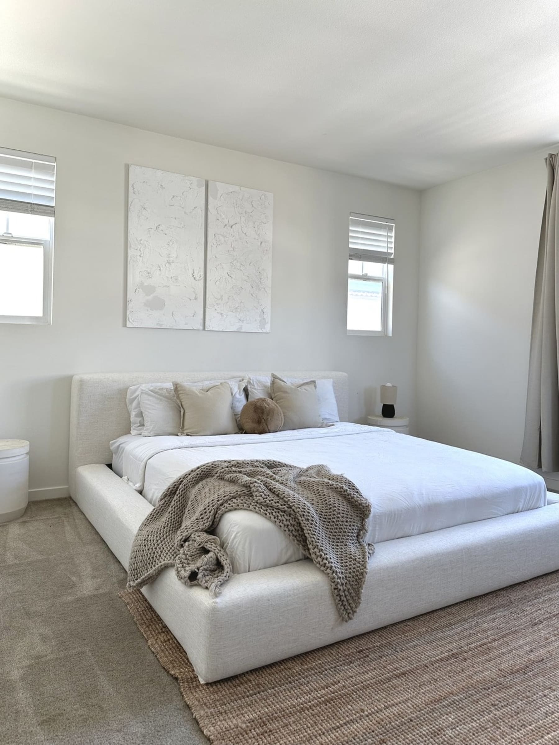 A platform bed frame with a brown throw.