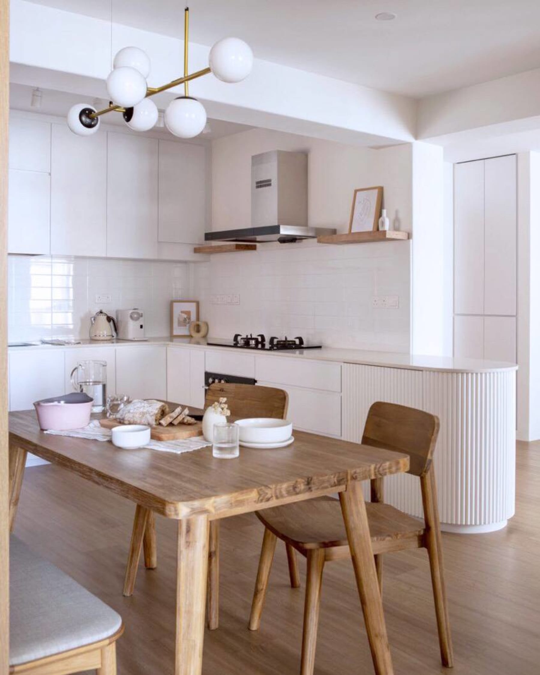 A wooden dining table paired with white dining chairs.