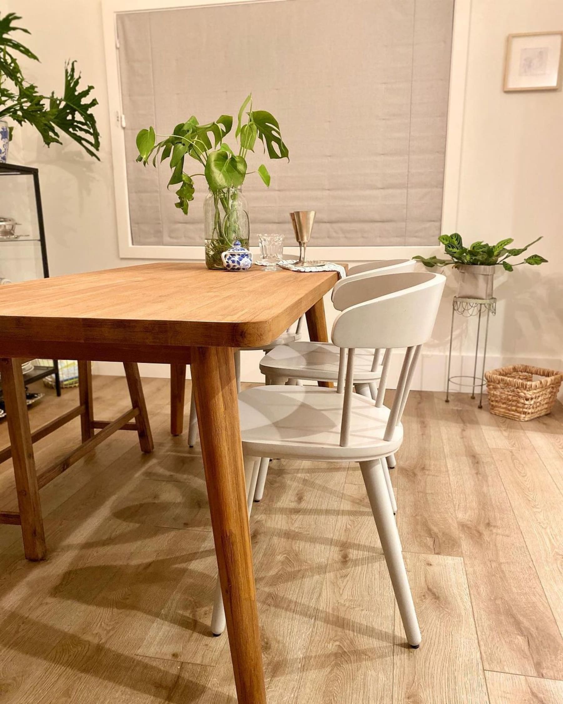 A wooden dining table paired with white dining chairs.