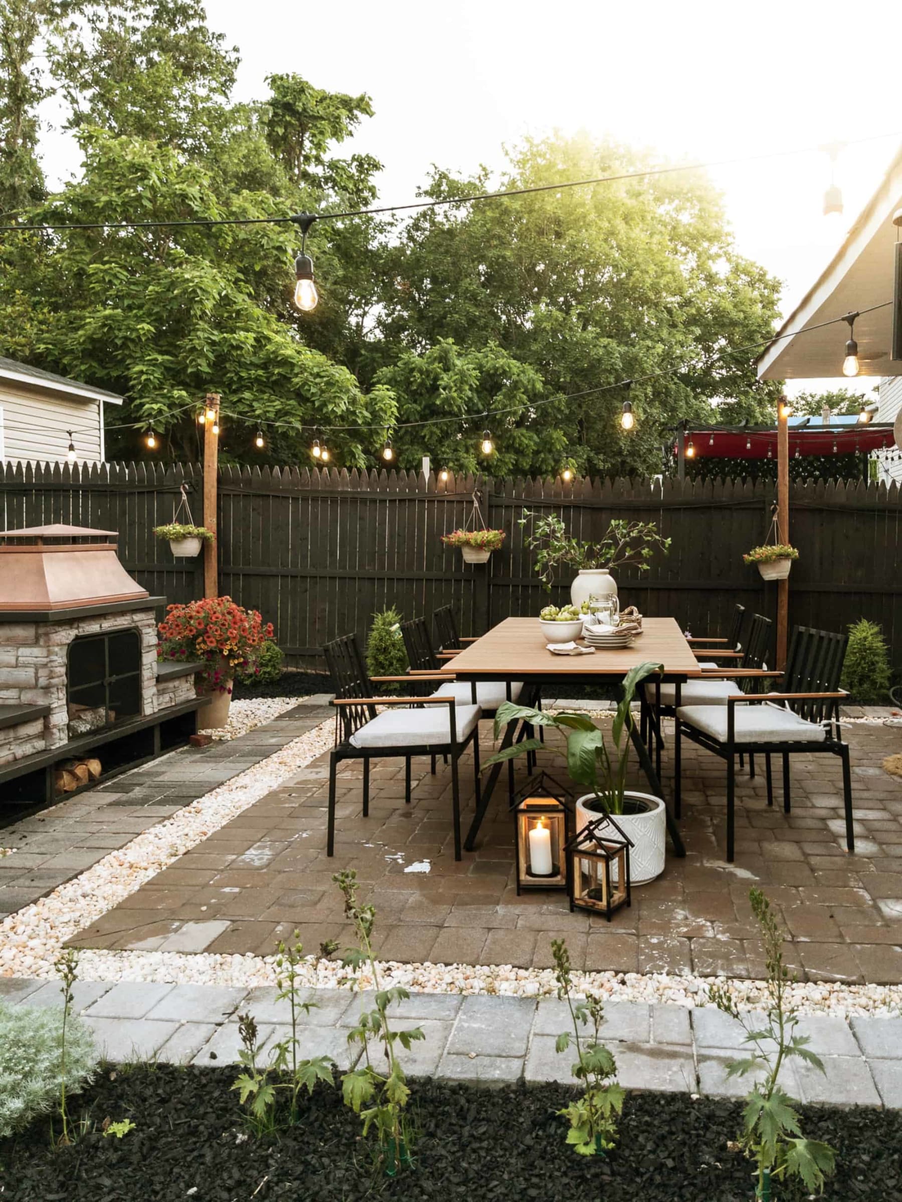 A dining table and chair set placed outdoors by a woodfired oven.