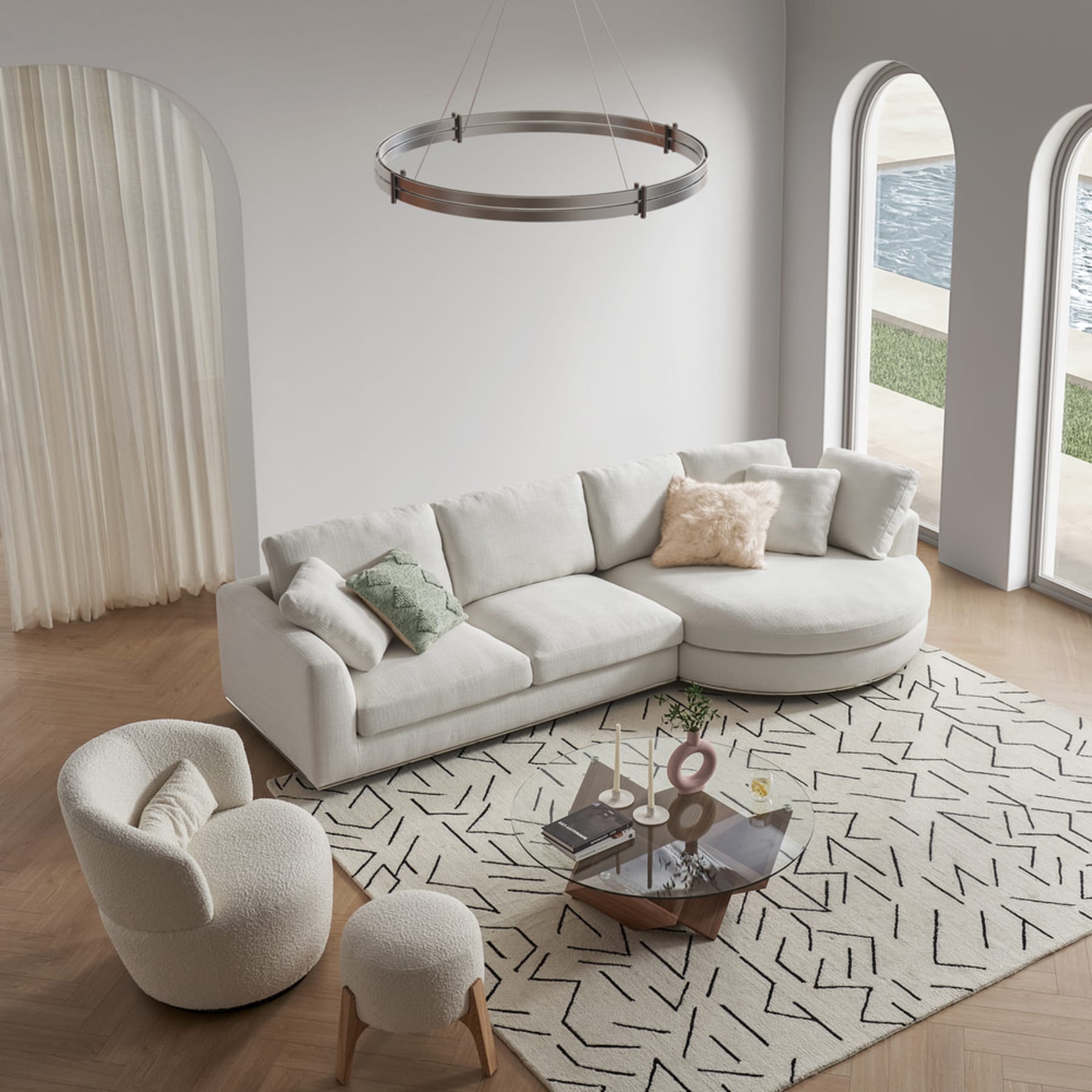 A white round chaise sectional sofa, swivel armchair with a stool, and coffee table with a glass tabletop in a living room.