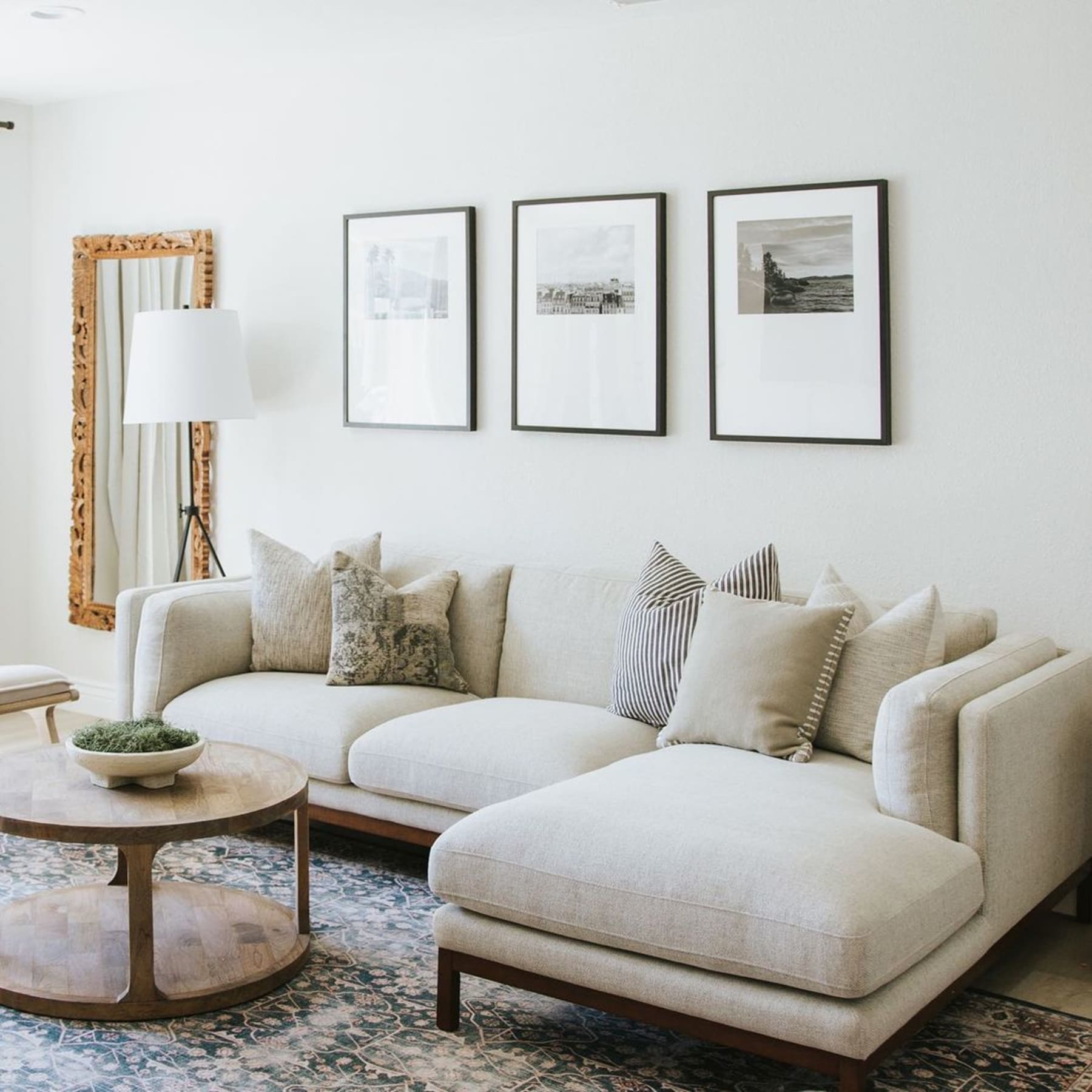 A right-hand facing chaise sectional sofa and a round wooden coffee table atop a rug.