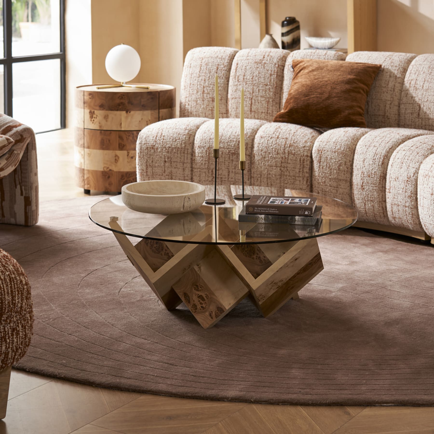 A glass coffee table atop a rug in a living room