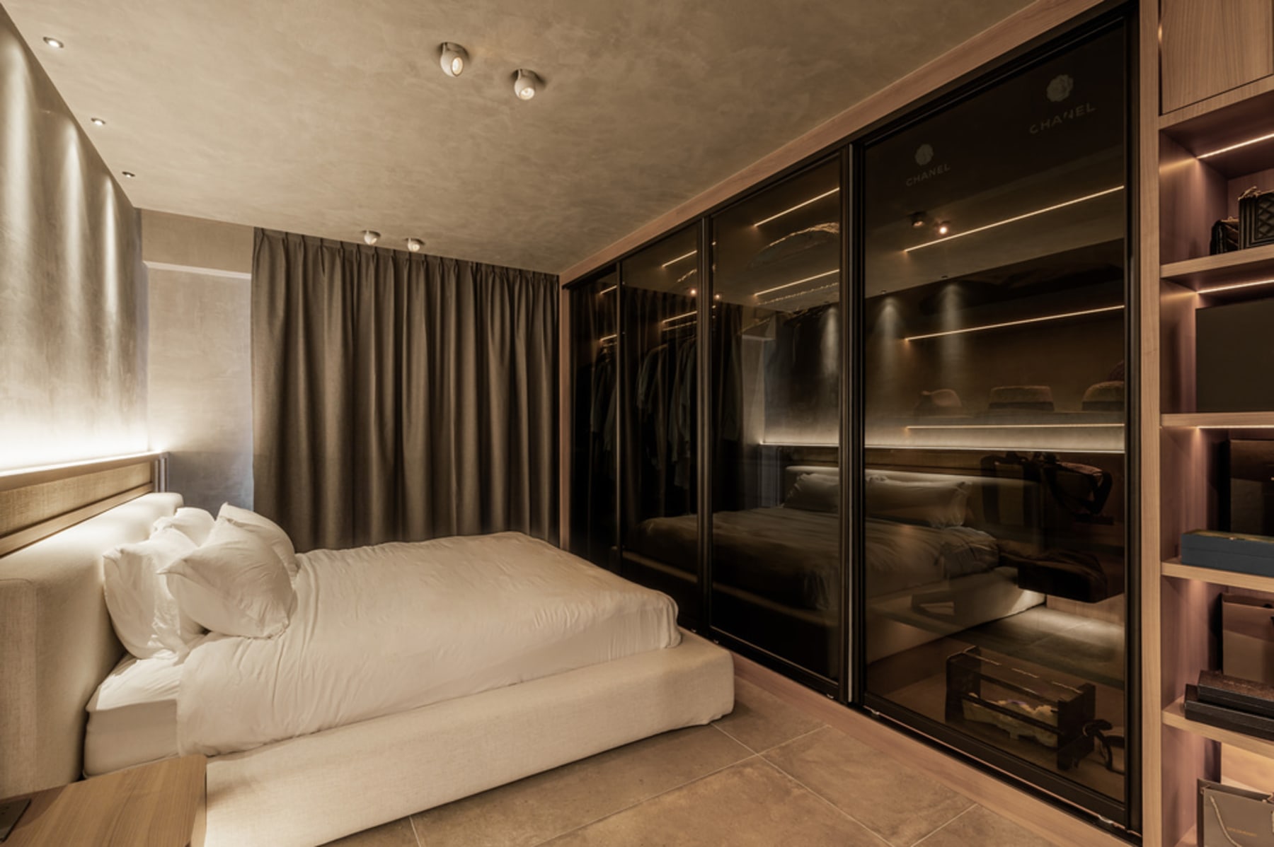 A platform bed in front of a built-in wardrobe with sliding doors.