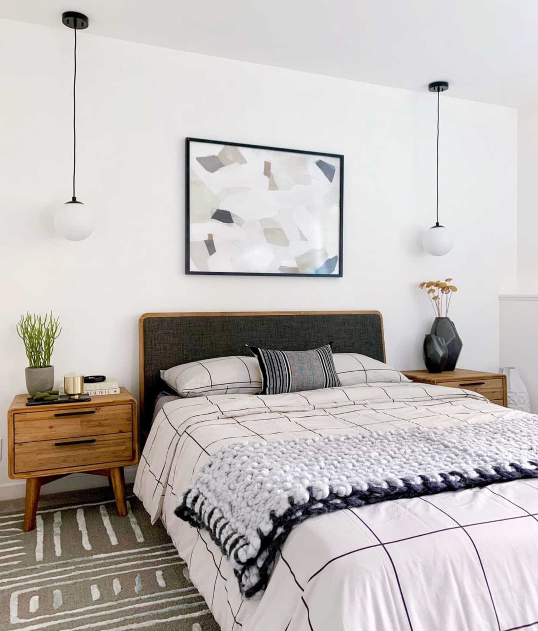 A matching bed frame and bedside table set with checkered bed sheets.