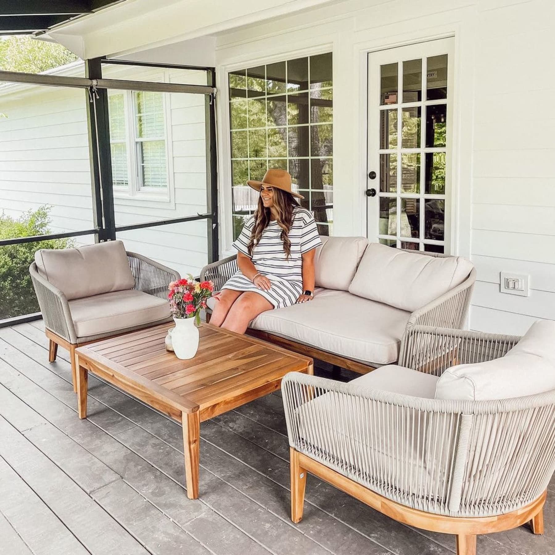 A person sitting on a loveseat on their patio.