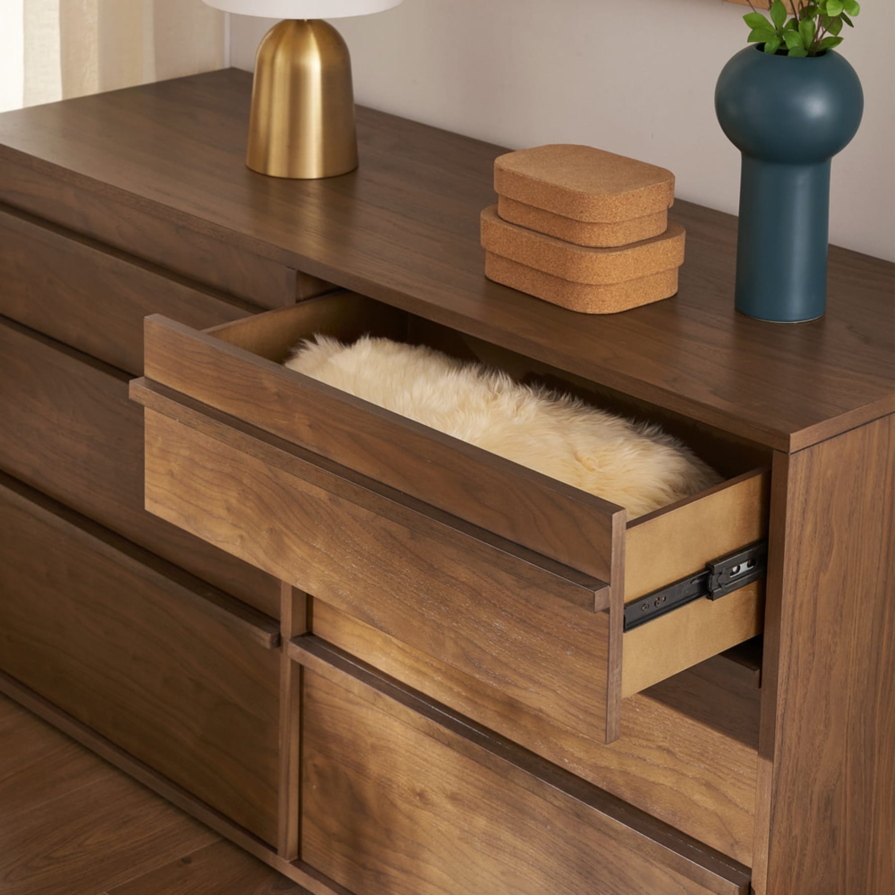 A 6-drawer dresser with one of its drawers opened to reveal a faux fur fabric.