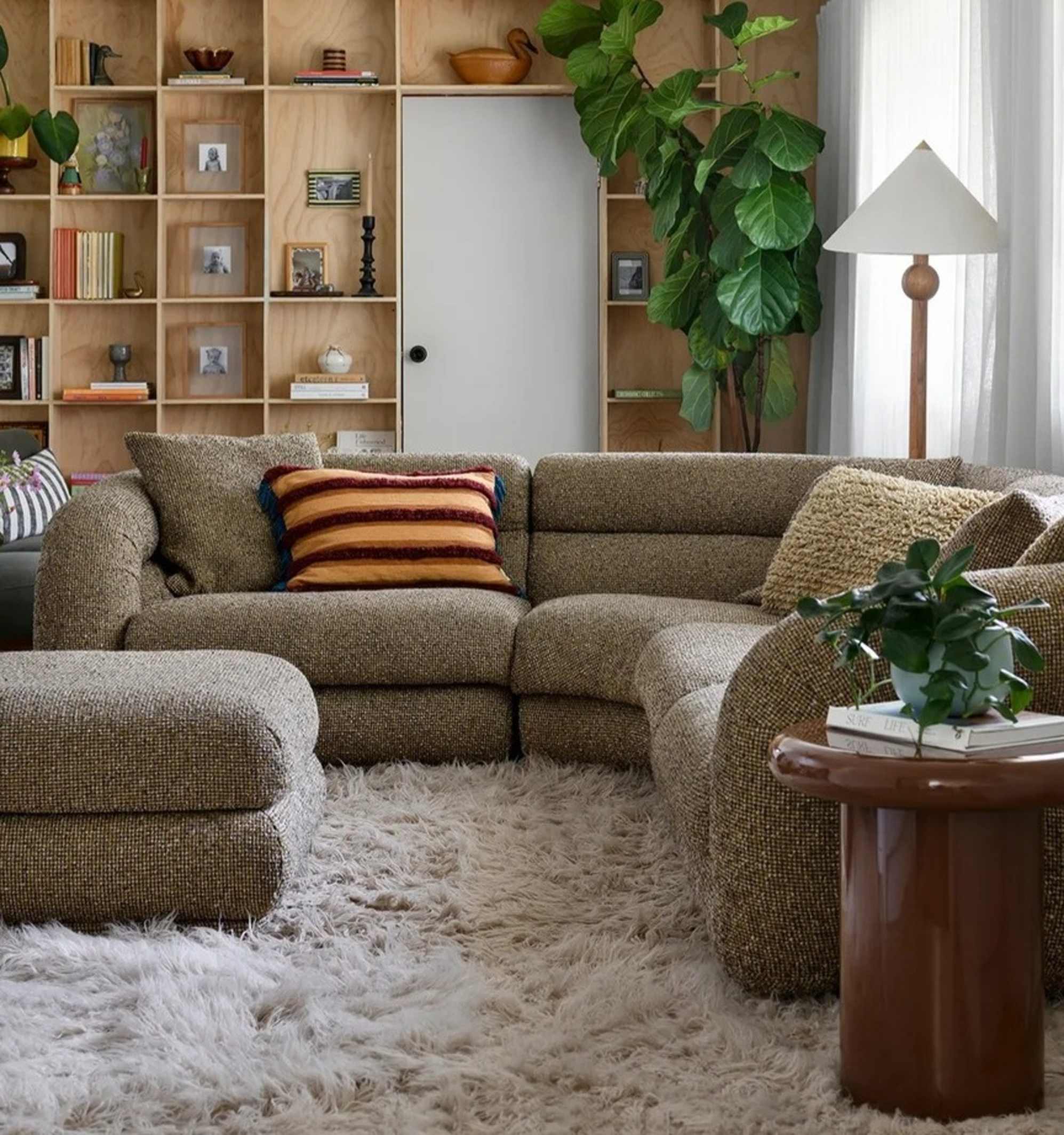 A moss green performance fabric sectional sofa placed atop a wool area rug in the living room.
