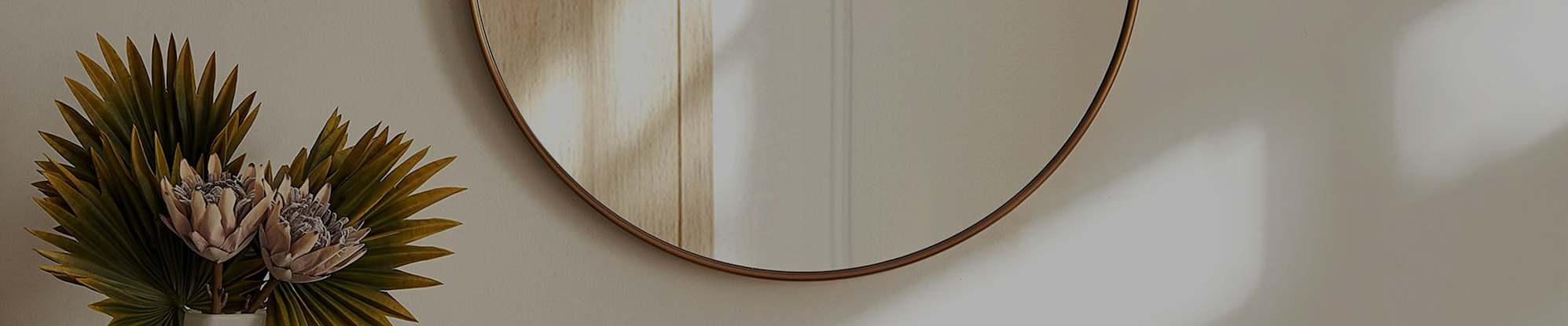 A round wall mirror mounted on a wall.