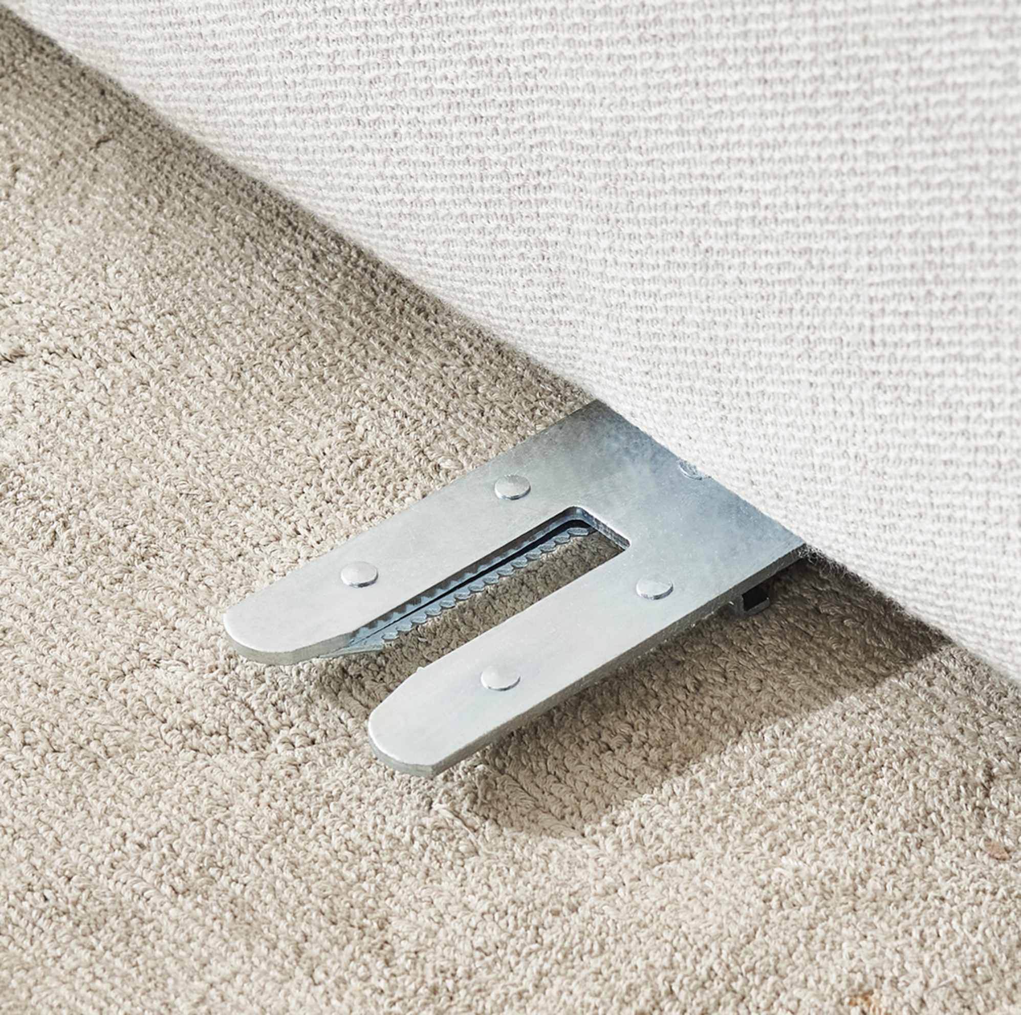 A close-up of an alligator clip beneath a sofa unit.