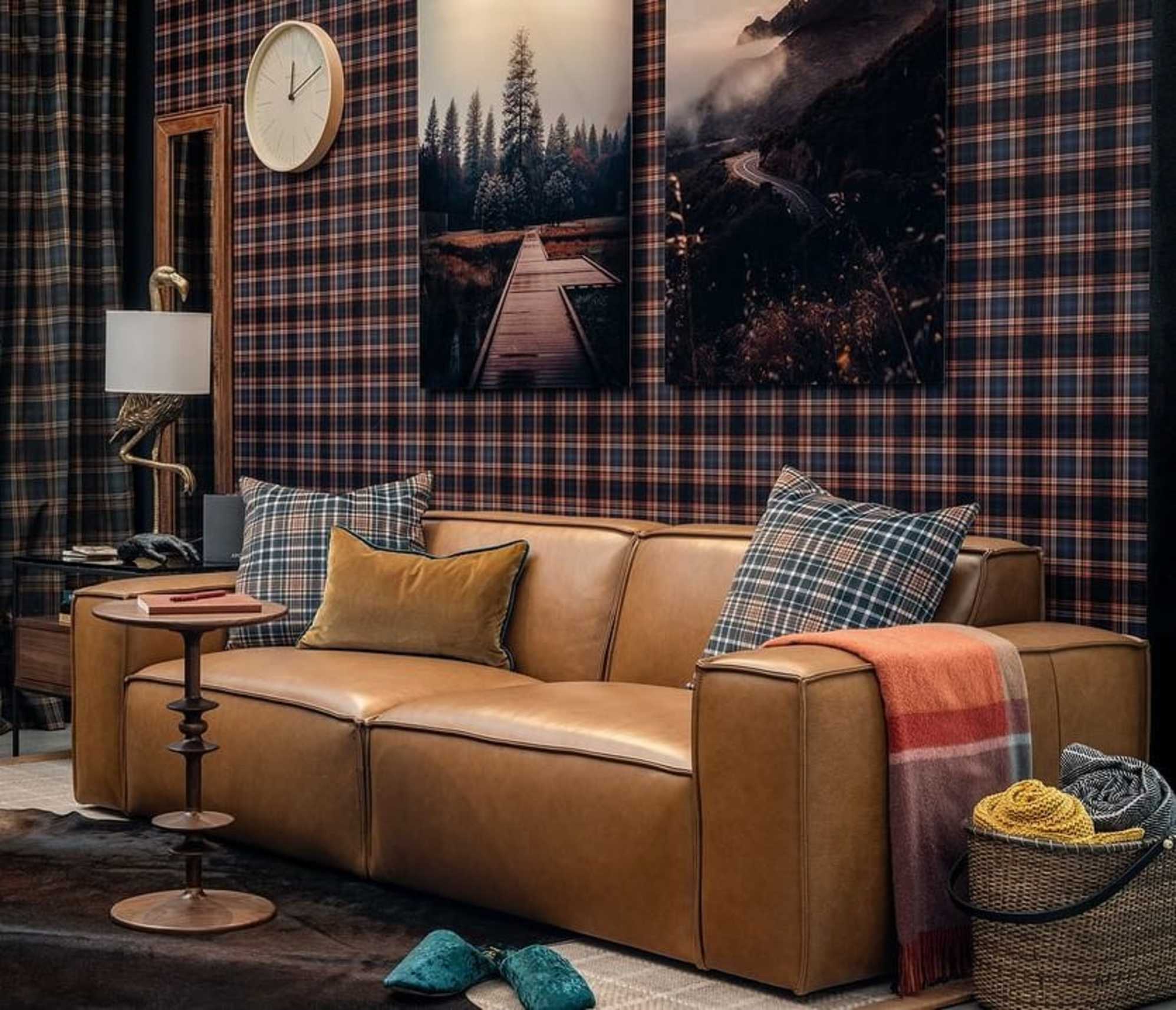 A leather sofa in a living room with checkered wallpaper.