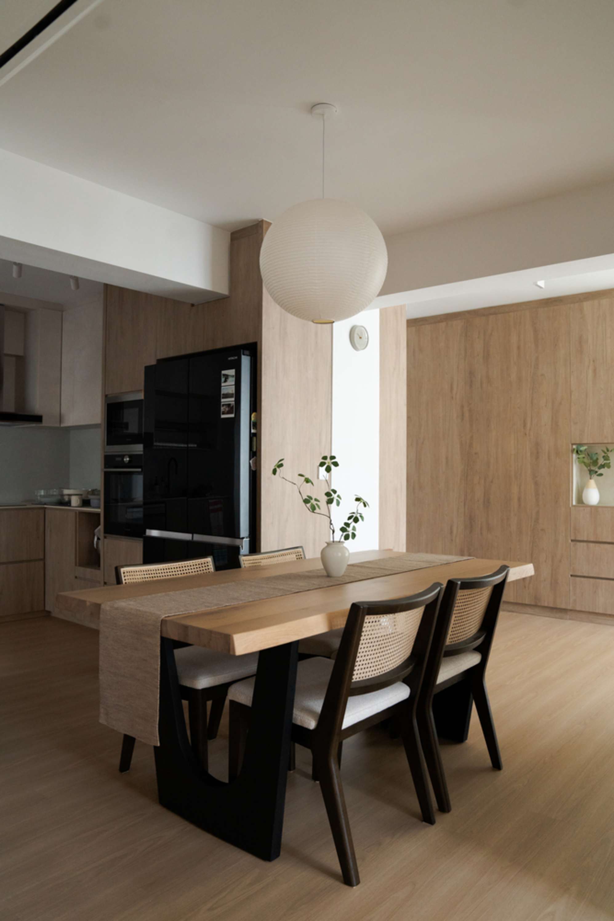 A wooden dining table with black cane dining chairs.