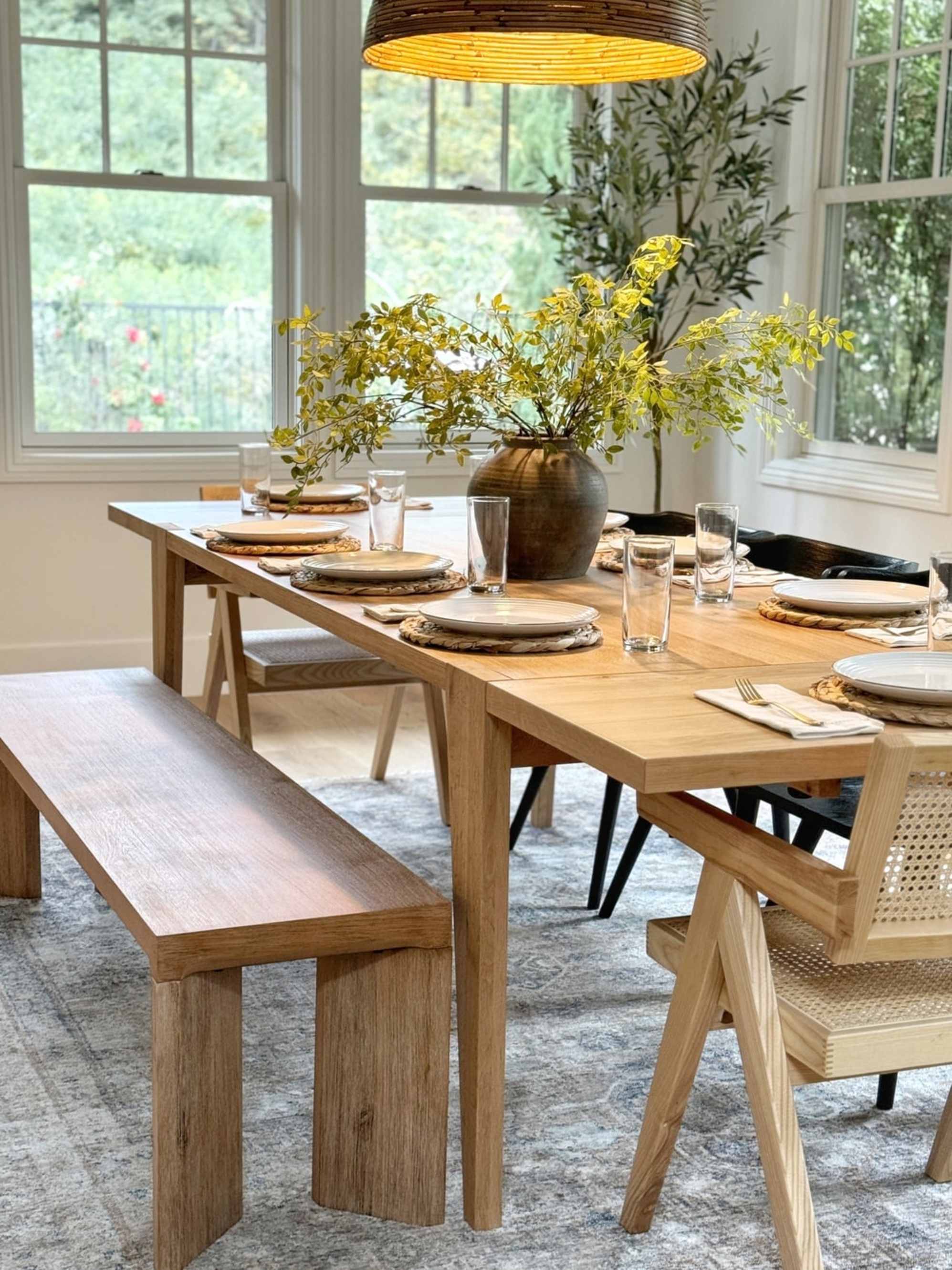 A wooden extendable dining table with a wooden dining bench.