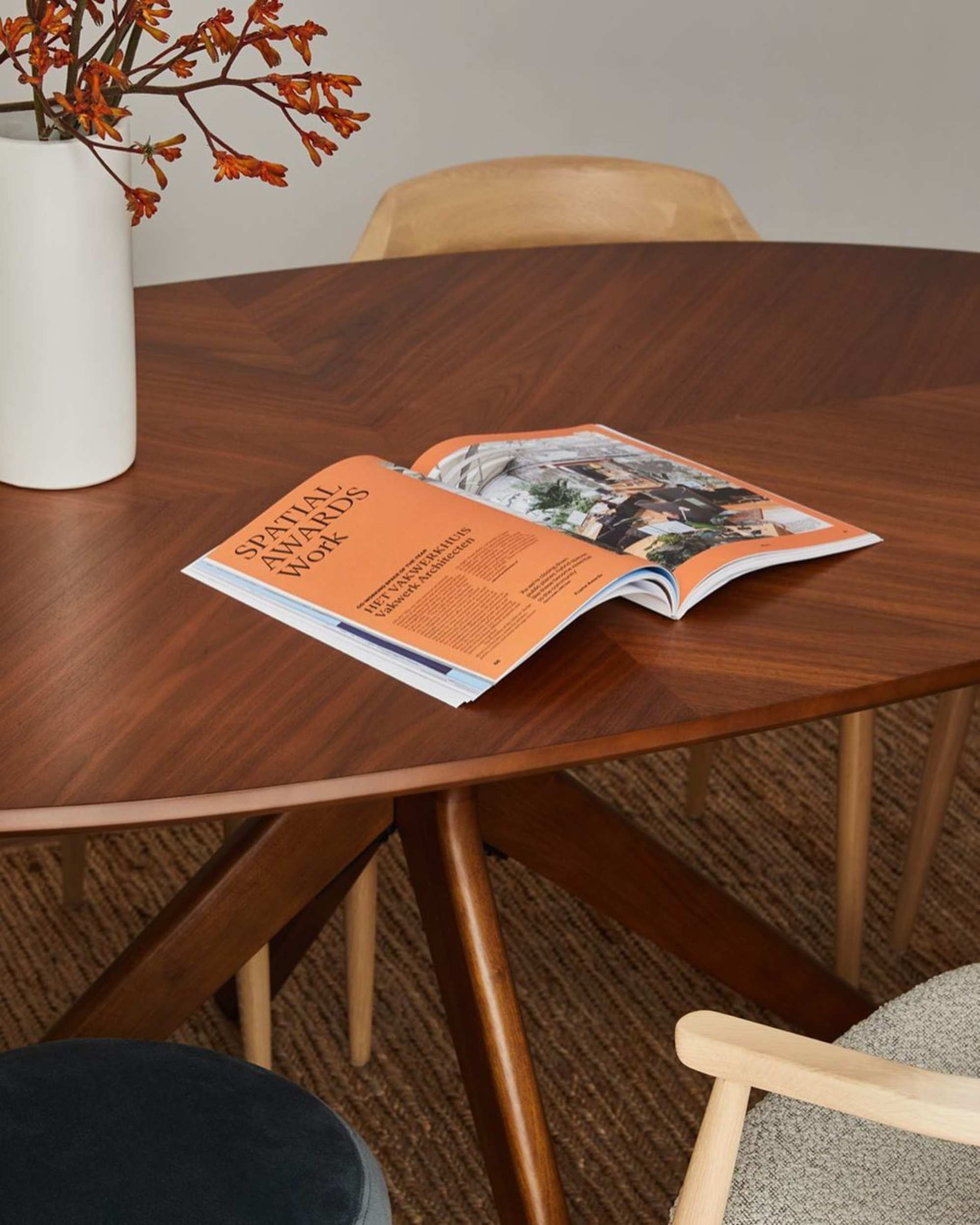 An open book on a wooden dining table.