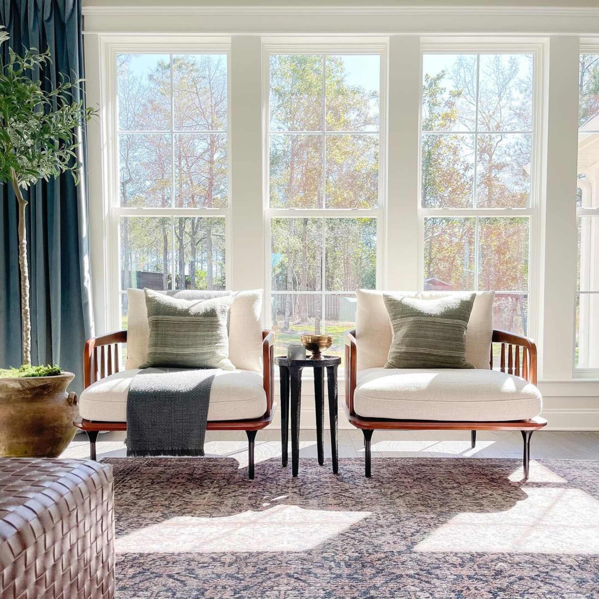 Two identical armchairs placed side by side in front of windows. 