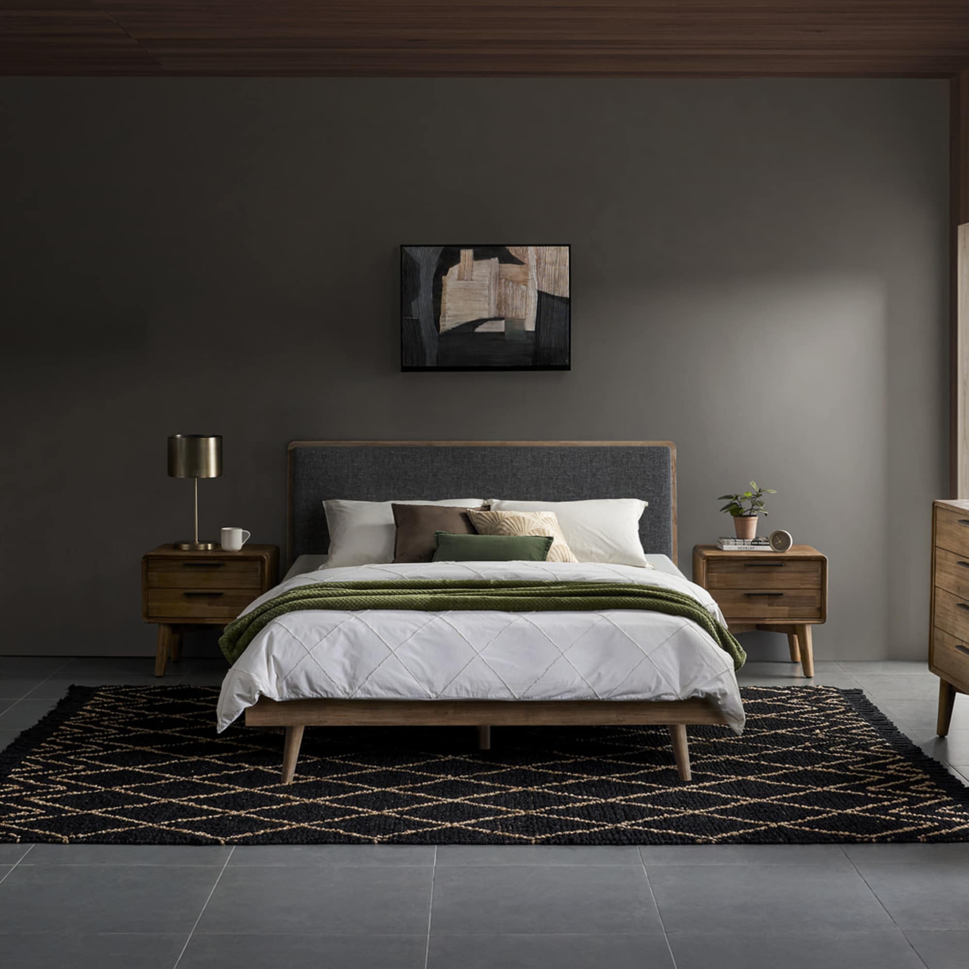 An acacia wood bed with two matching acacia wood nightstands placed in a bedroom.