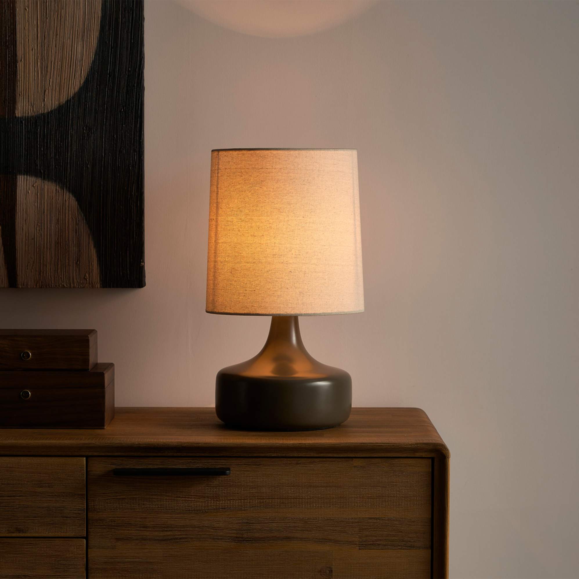 A lamp with a sculptural base and black glazed base.