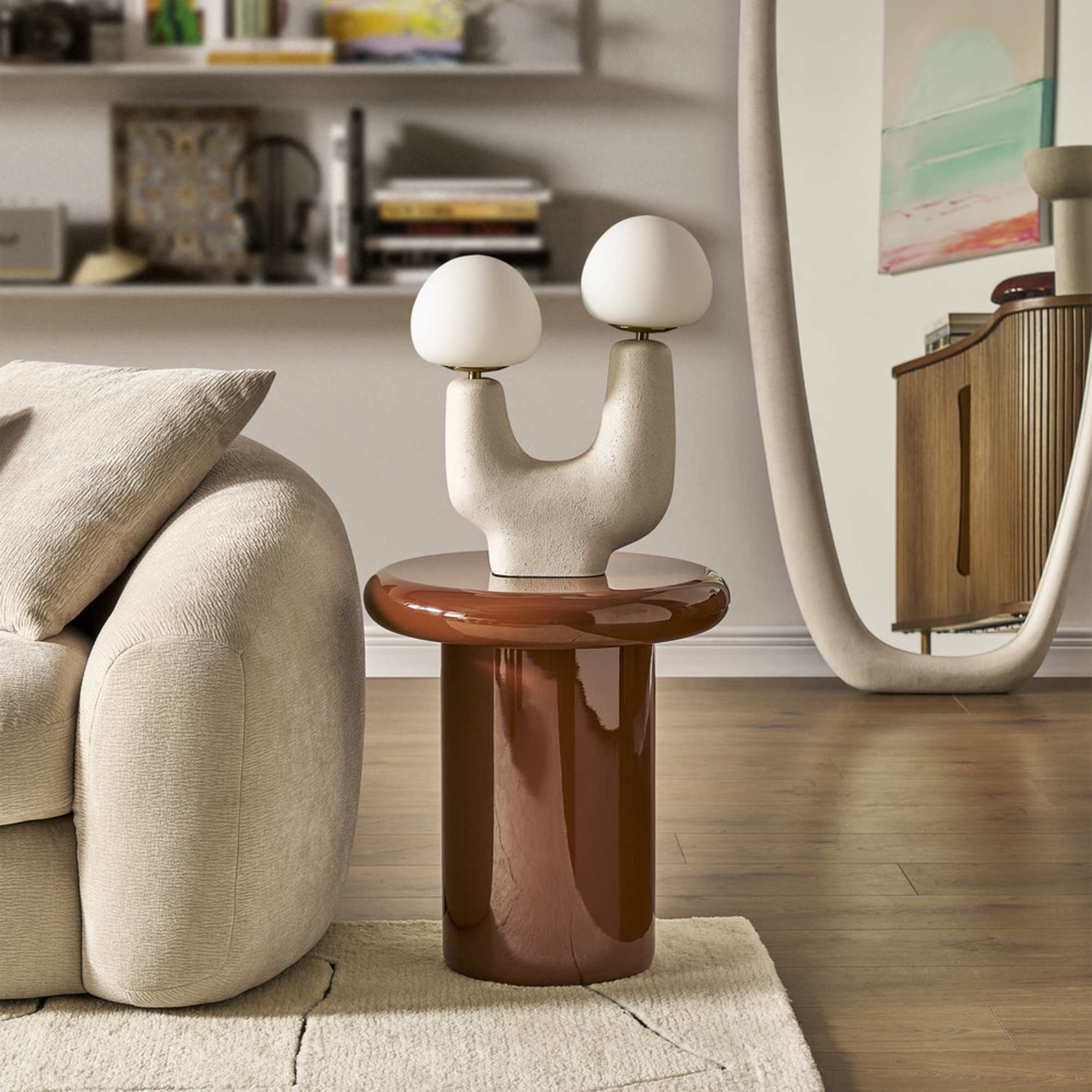 A duo bulb sculptural table lamp placed on a brown side table.