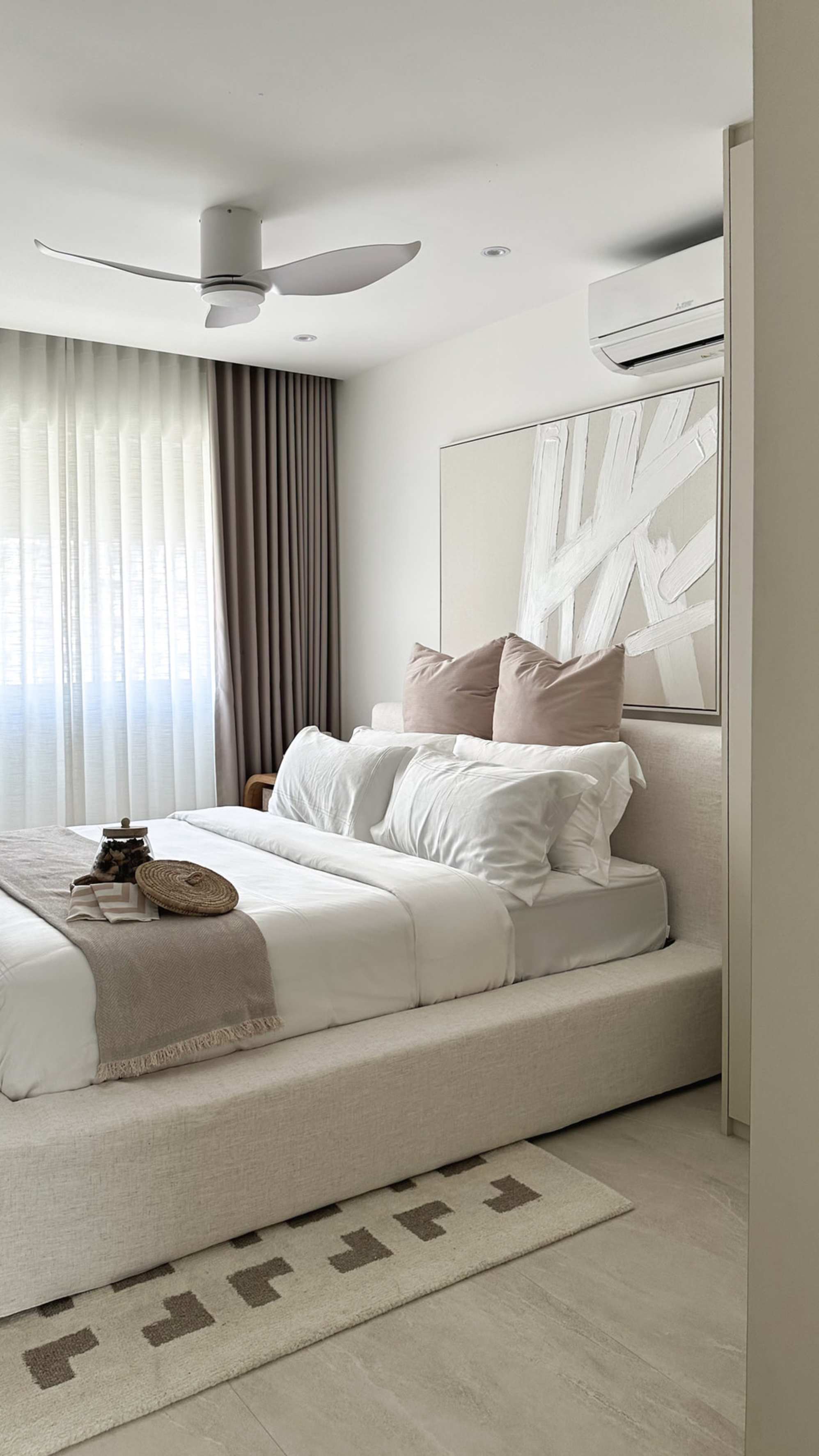 A storage bed with a piece of artwork hanging on the wall behind the bed frame.