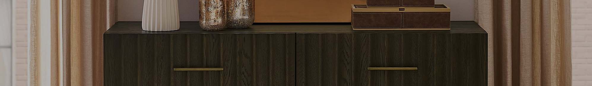 A dark wood dresser with brass handles.
