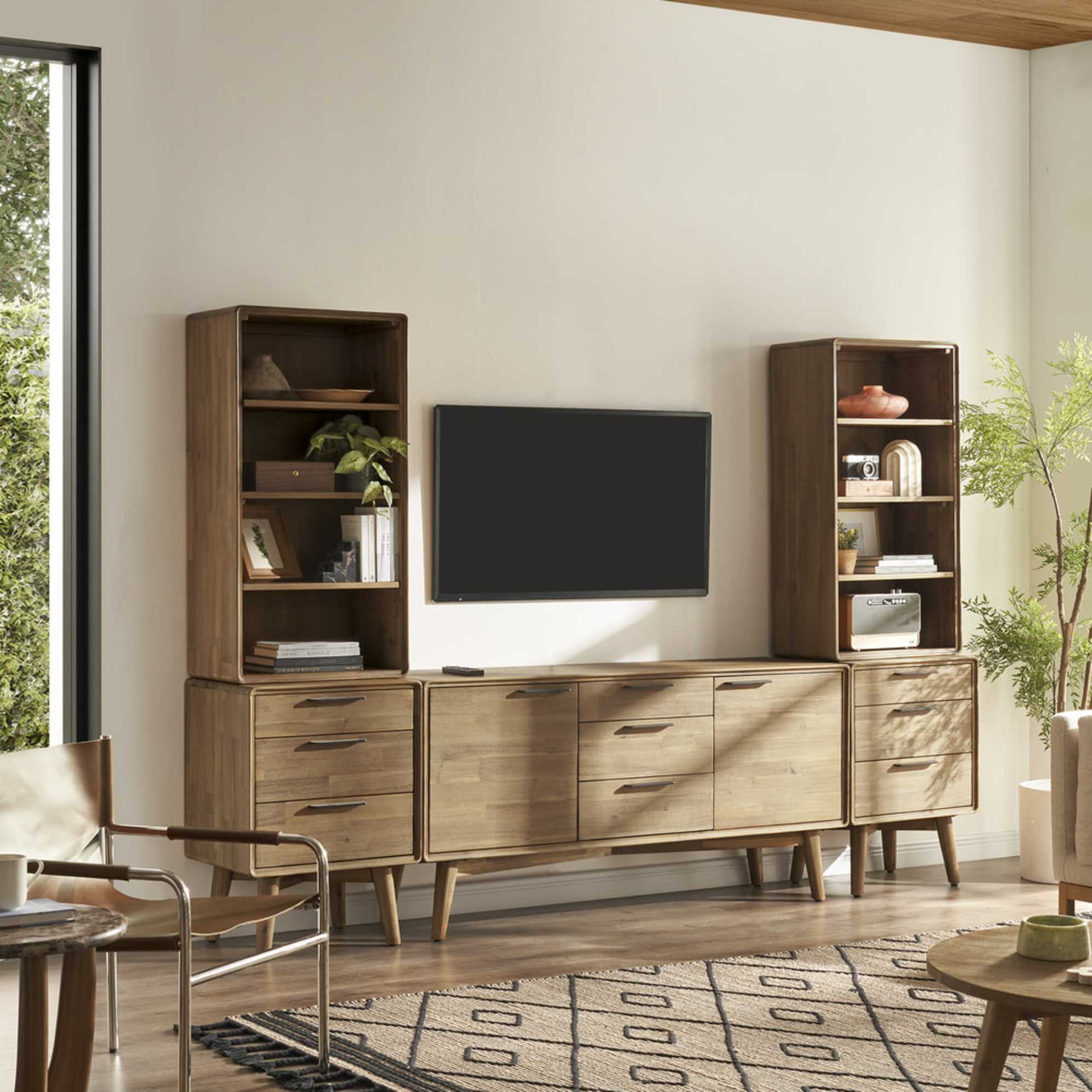 An acacia wood console storage system with a TV mounted in the middle.