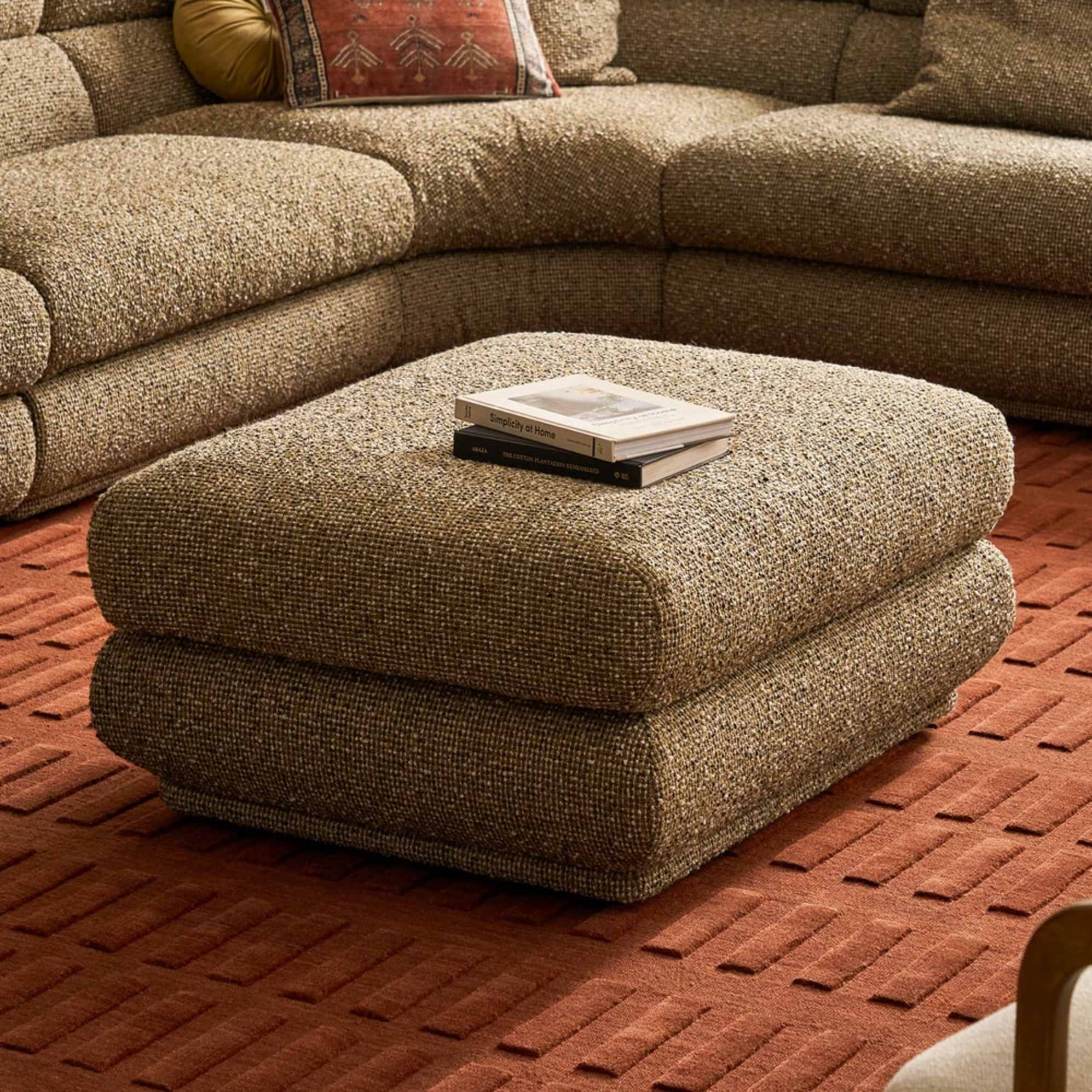 Two books placed atop an ottoman.