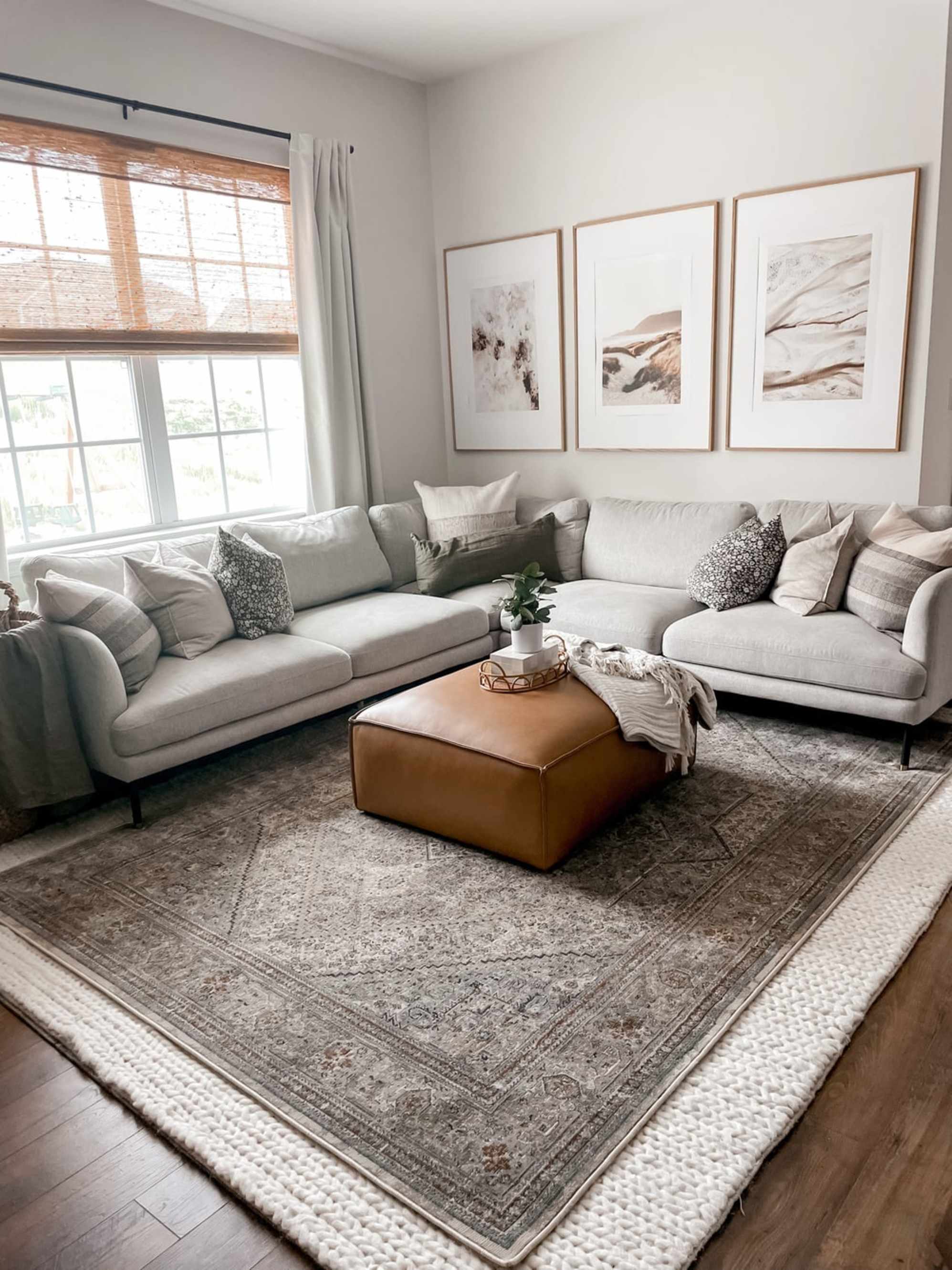 A leather ottoman placed in a living room with an l-shape sectional sofa.
