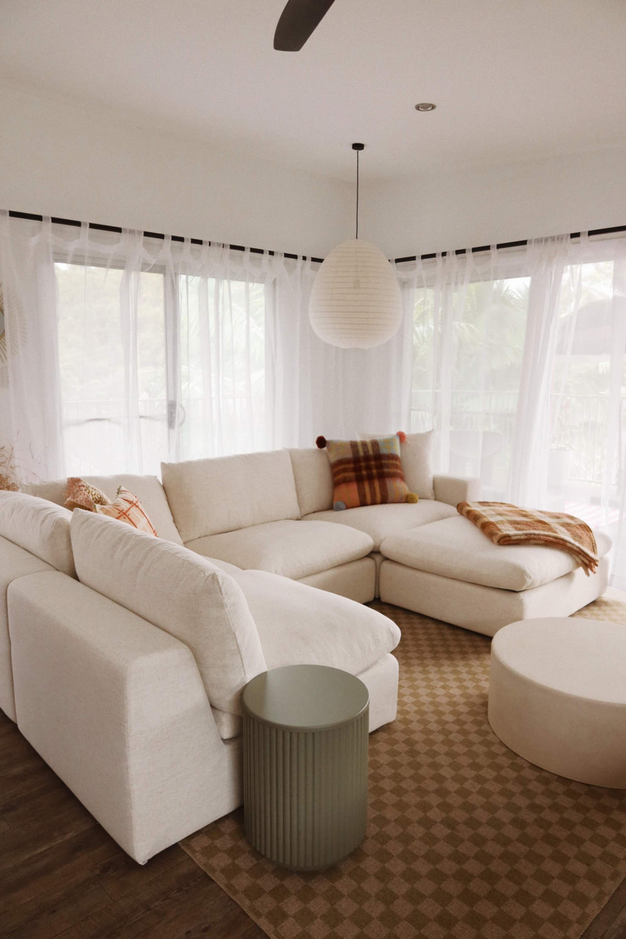 A chaise sectional sofa with a matching ottoman placed in a living room.
