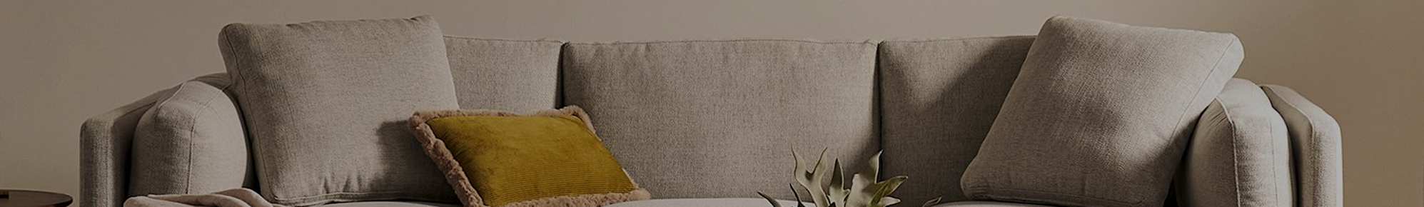 A grey sectional sofa with throw cushions. 