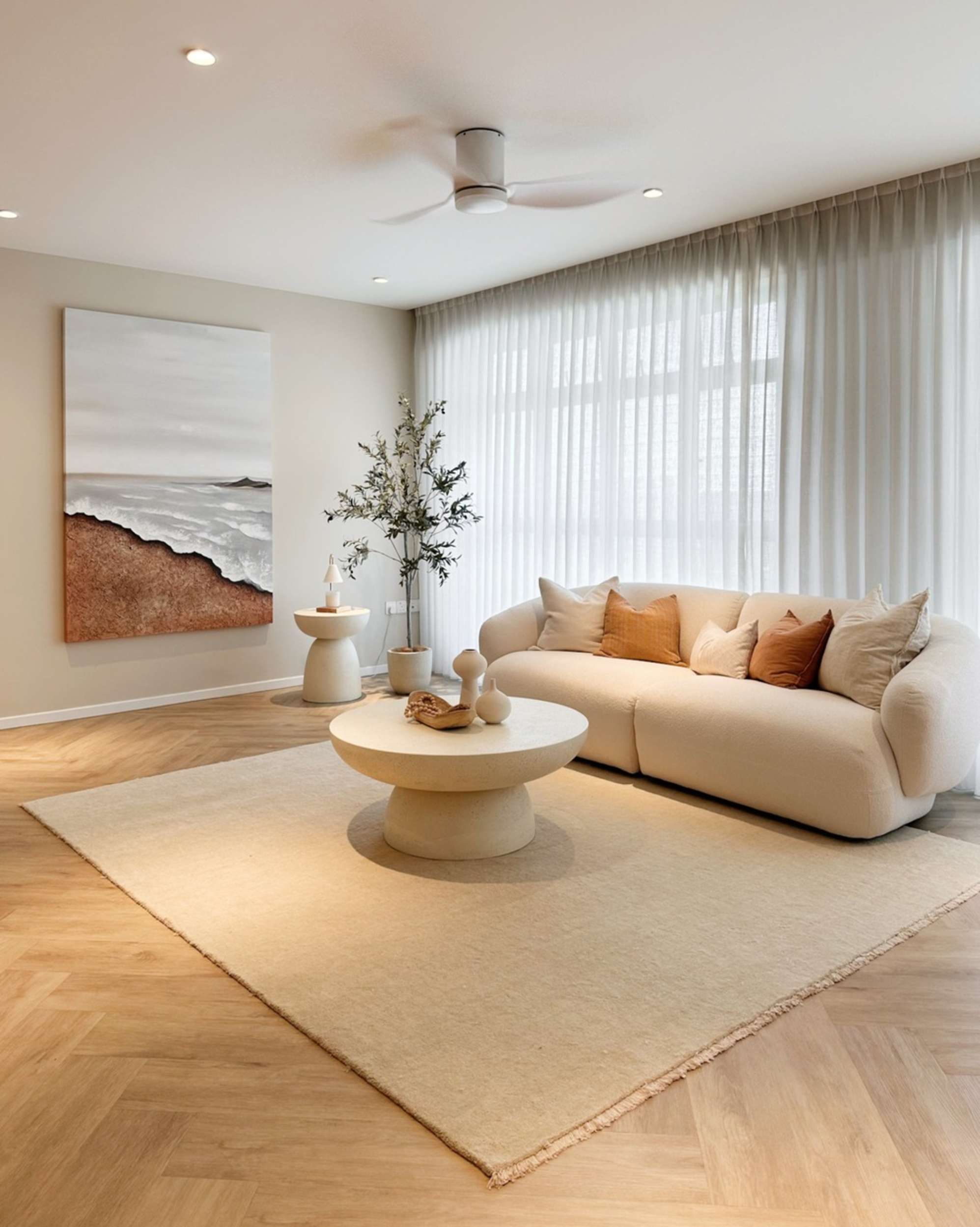 A performance fabric 3-seater sofa placed on a wool area rug with a round coffee table.