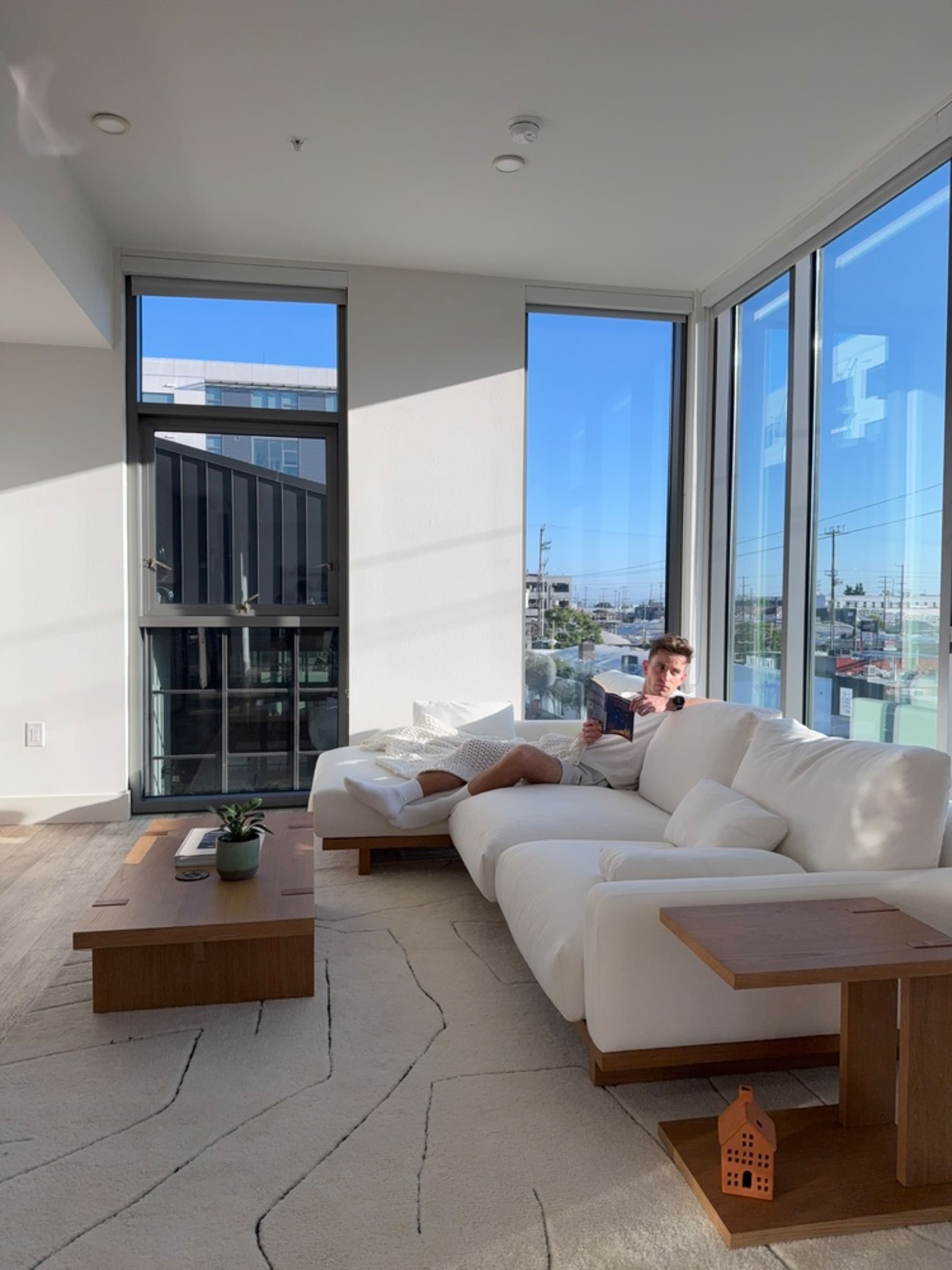 A person sitting on a sectional sofa in the living room.