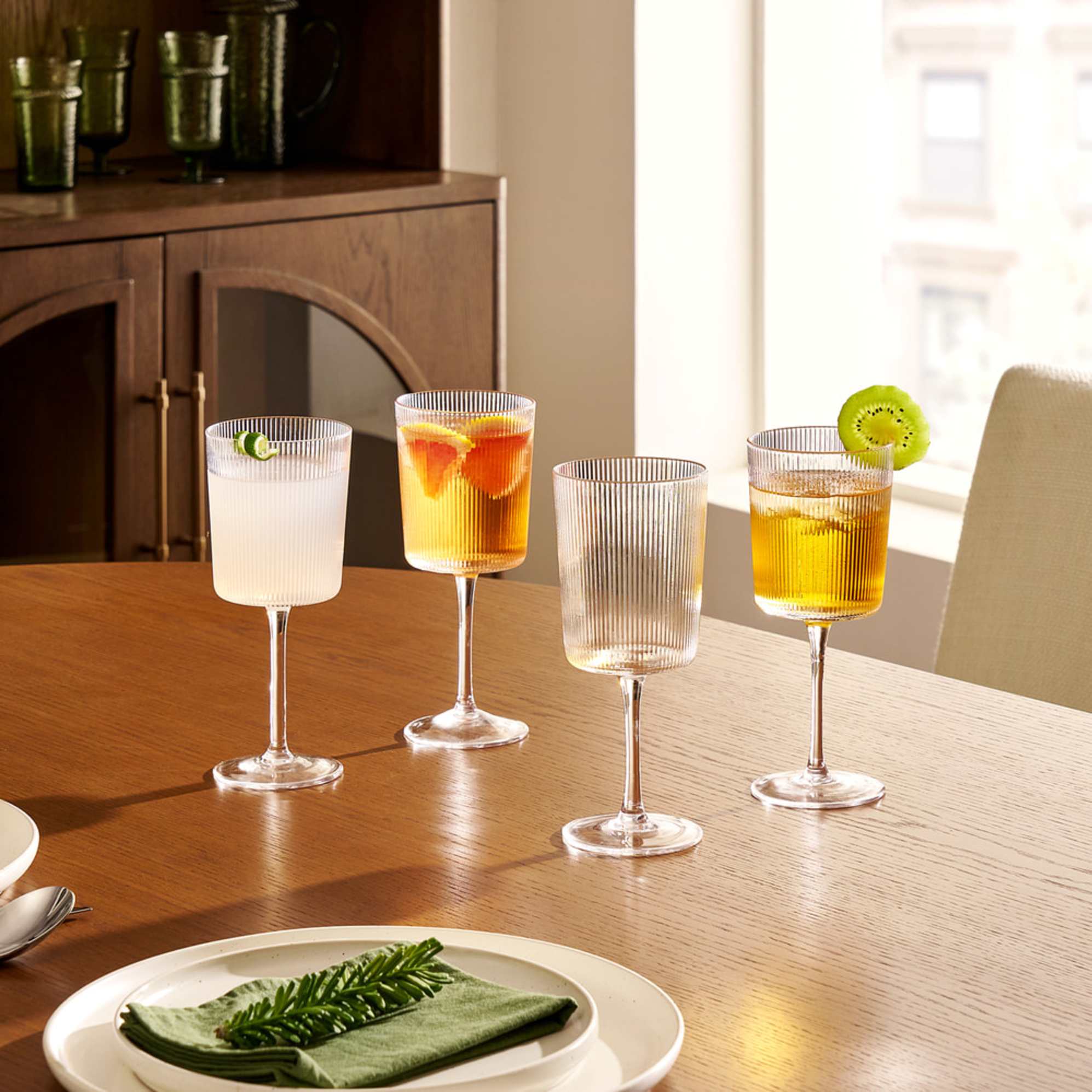 A set of four all-purpose fluted wine glasses placed on a dining table.
