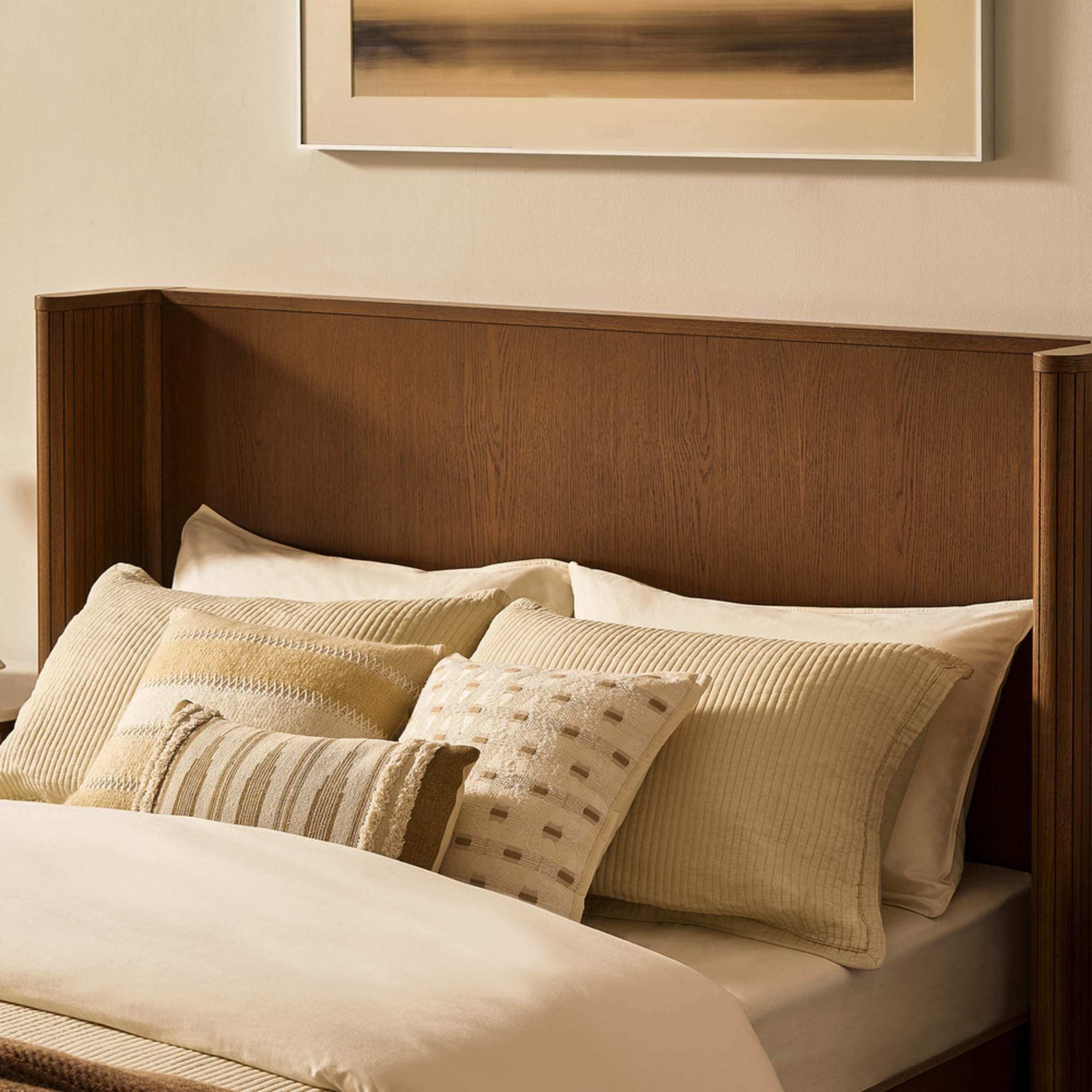A bed with a wooden wingback headboard.