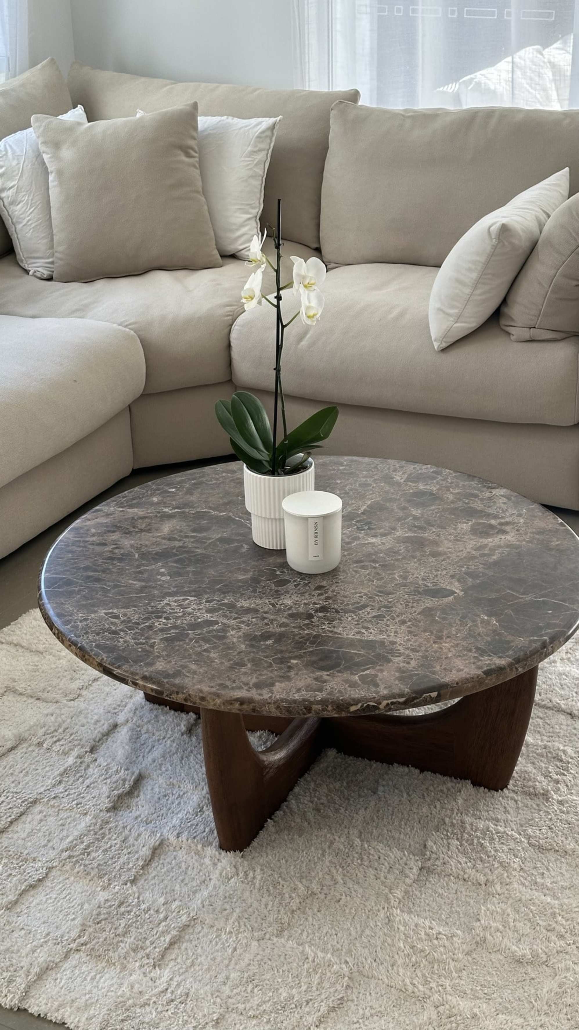A marble round coffee table placed in a living room.