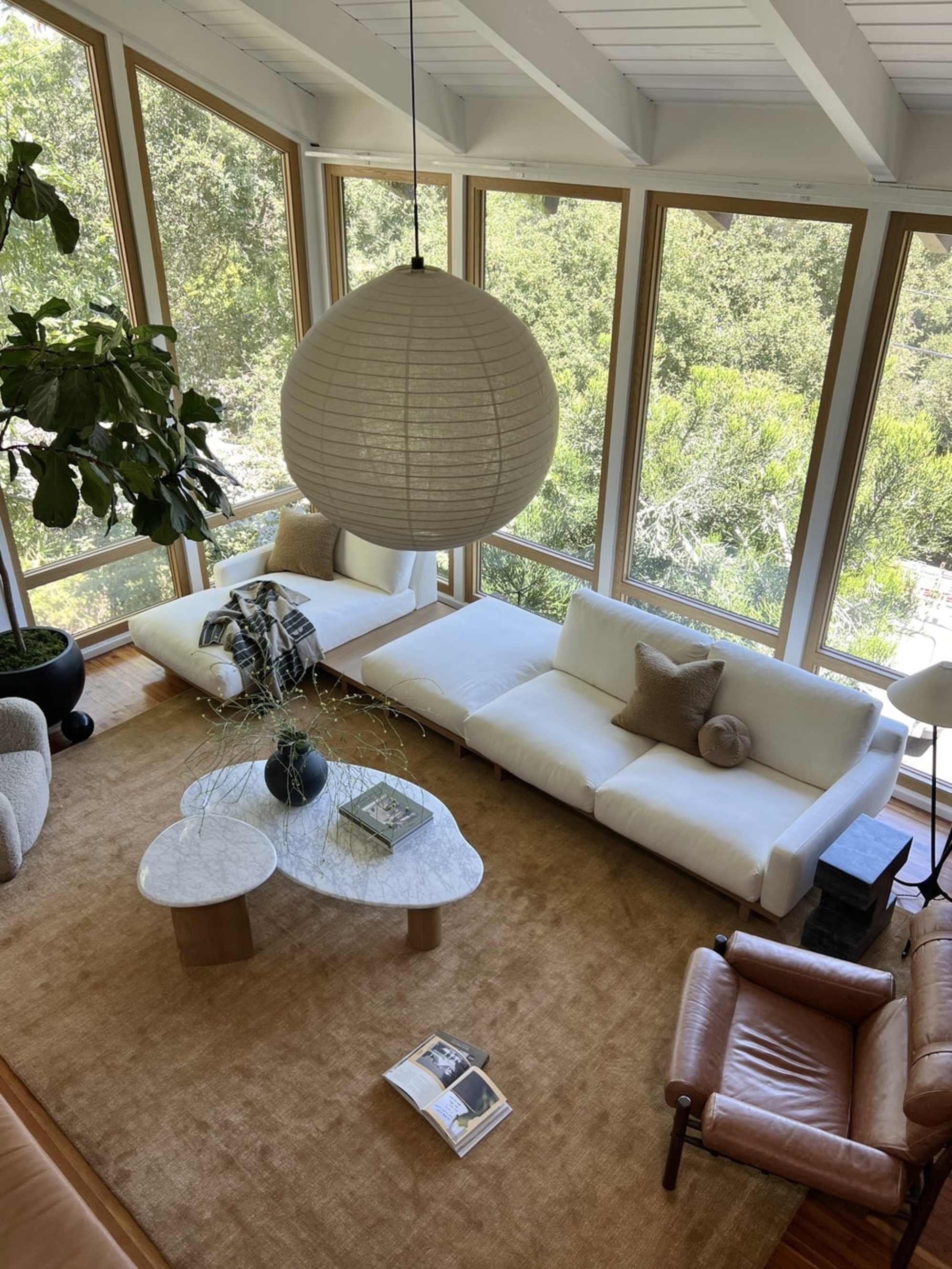 A marble coffee and side table set are placed in a living room with a sectional sofa.