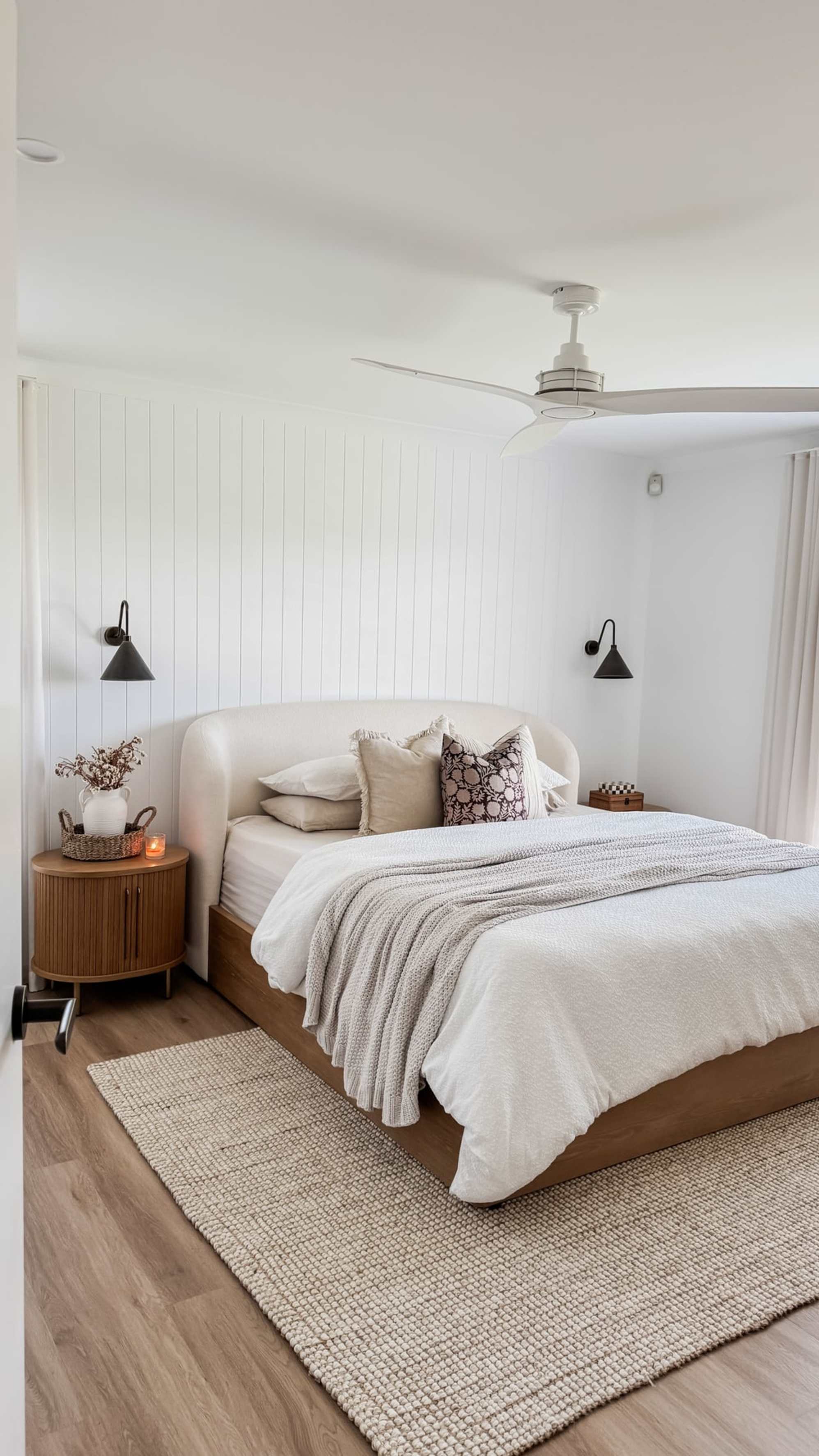 A performance bouclé storage bed and wooden side table in a bedroom.
