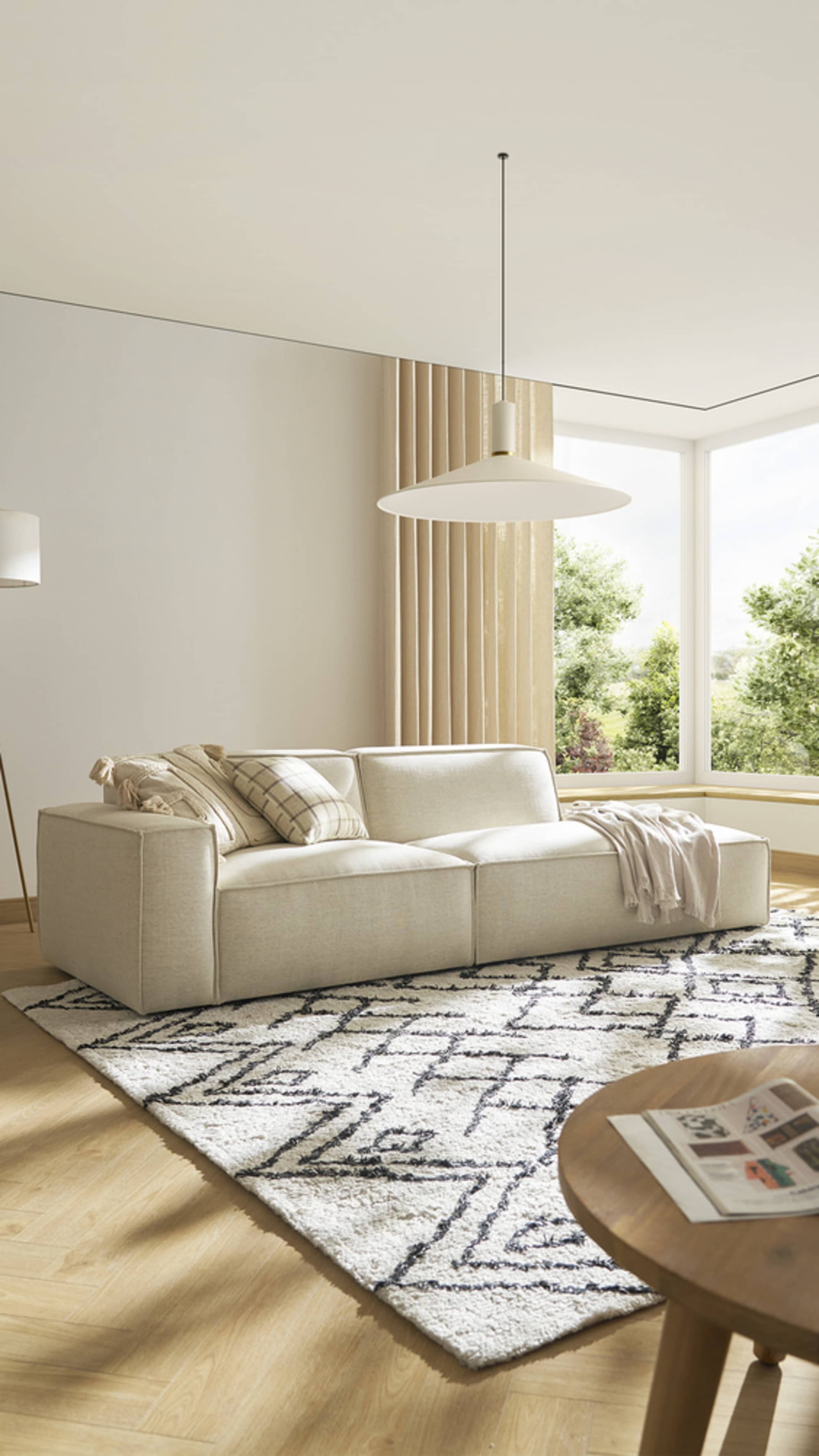 A side chaise sofa placed in an area rug with geometric patterns.