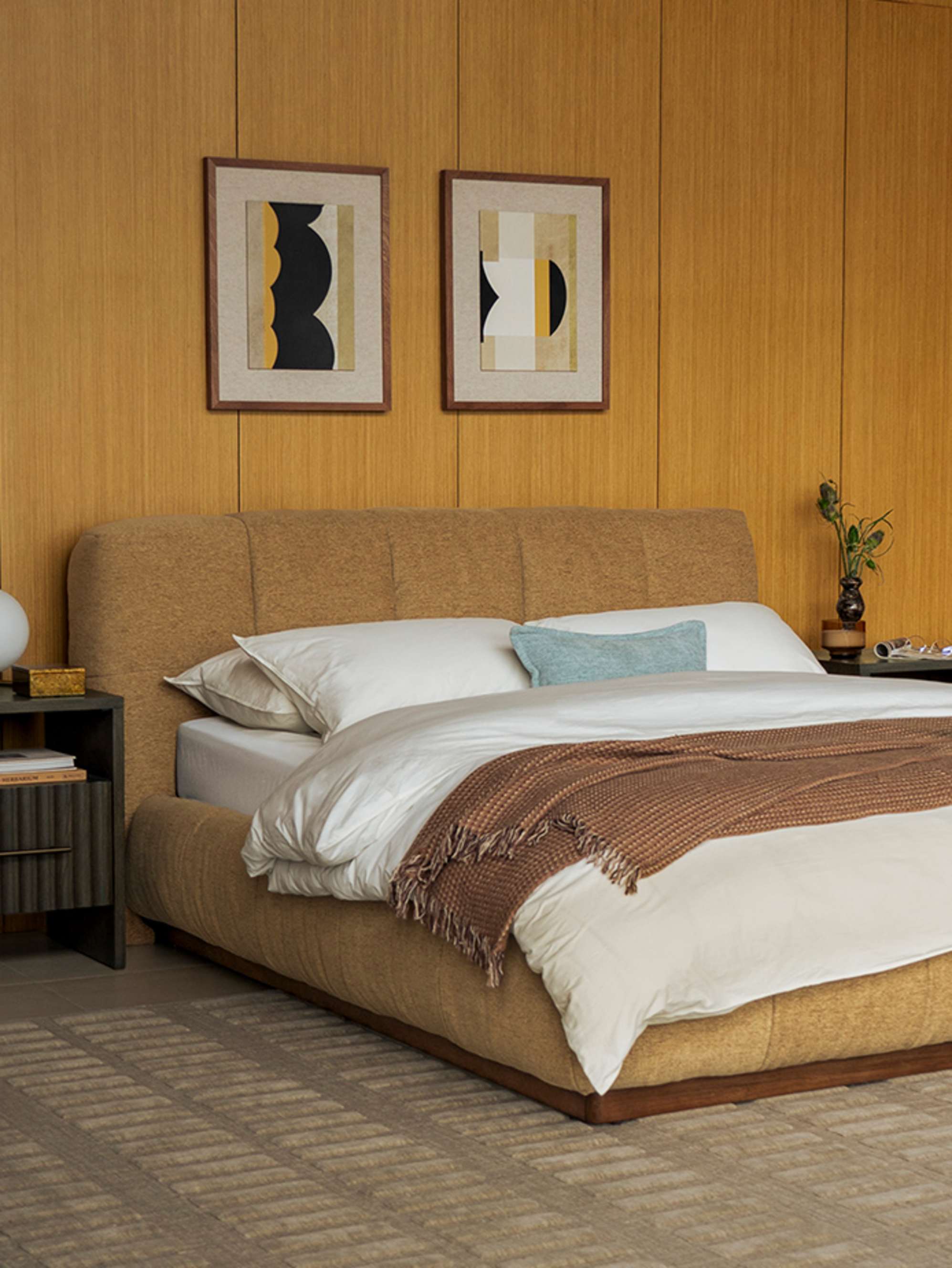 A wooden bed with a wingback headboard placed in a bedroom.