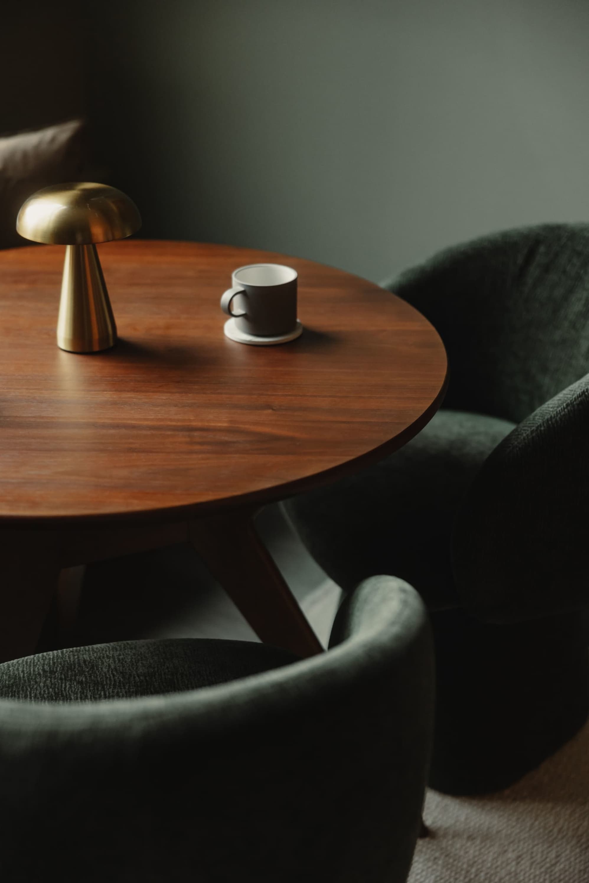 A small round dining table with two chairs with a woven seat.