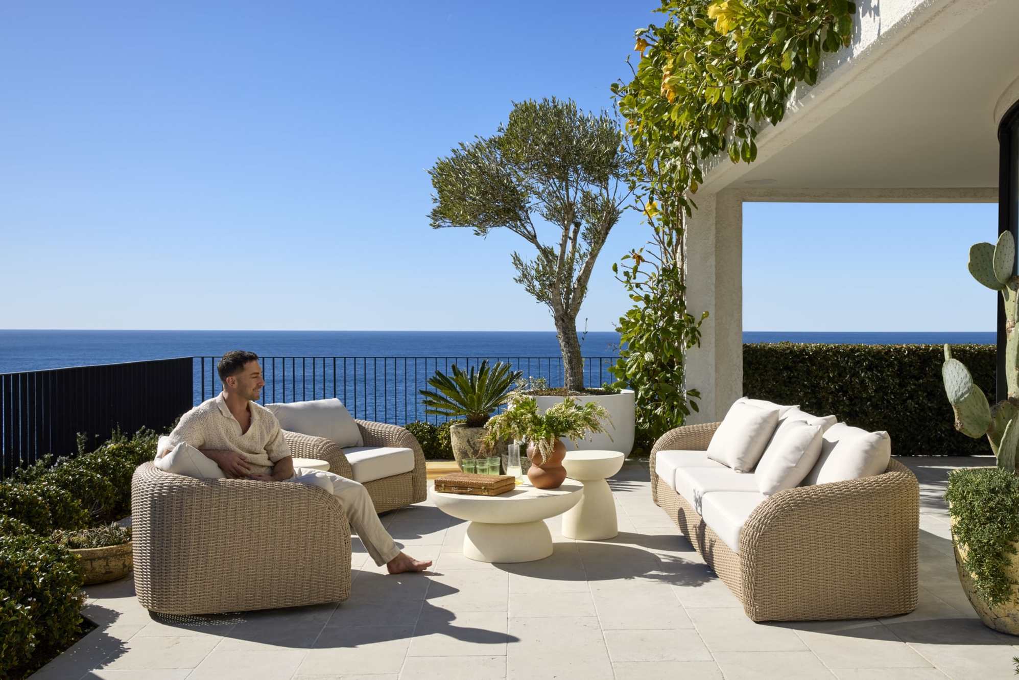A person sitting on an outdoor swivel lounge chair placed on a terrace