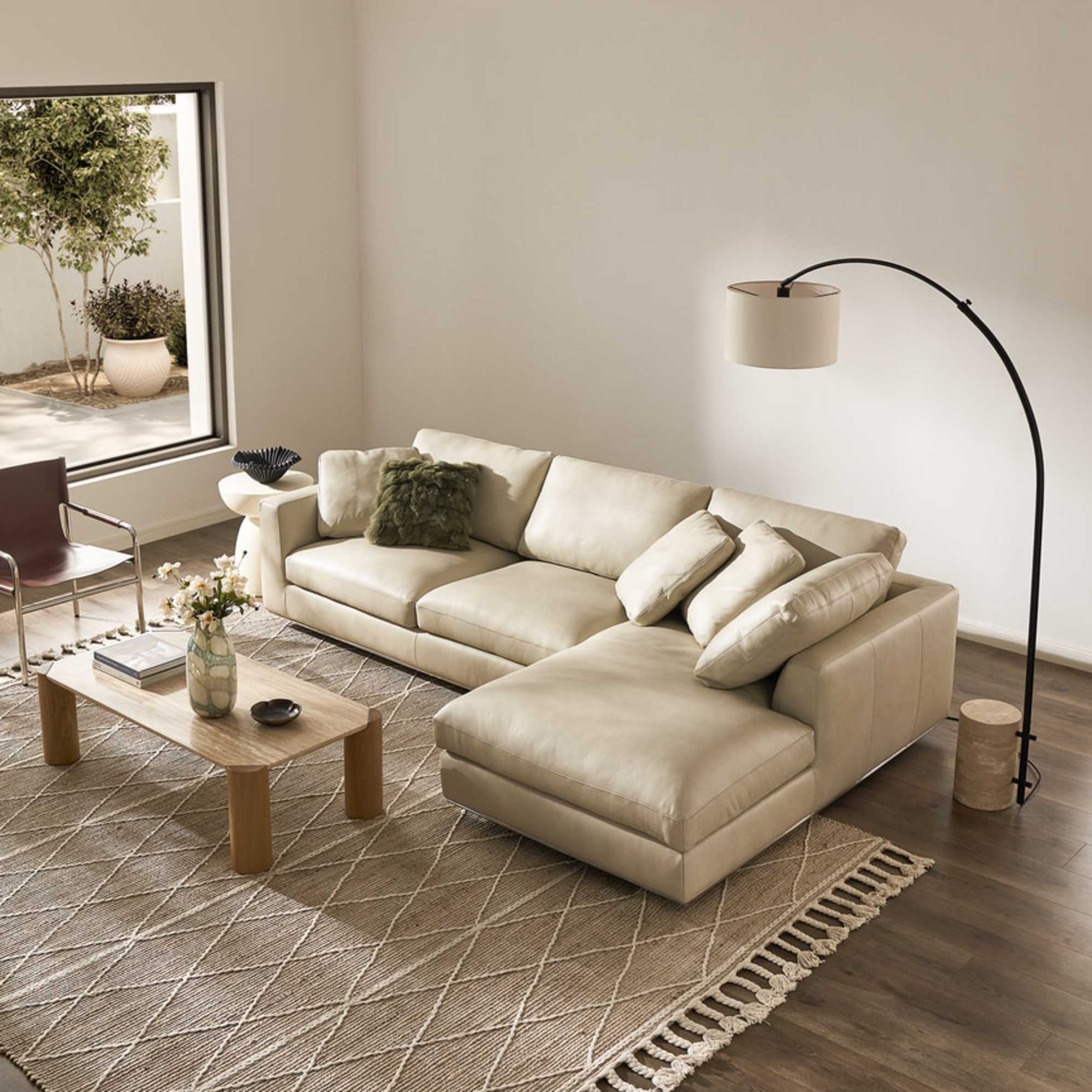 A leather chaise sectional sofa with a rectangular travertine coffee table.