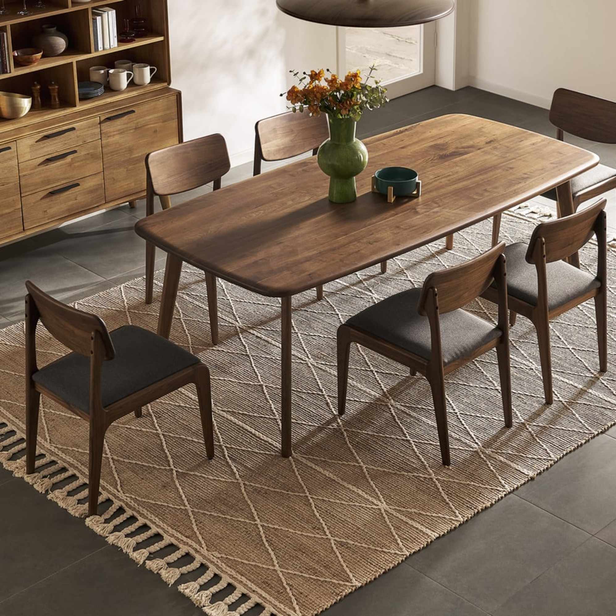 A walnut wood dining table and six matching walnut wood dining chairs.